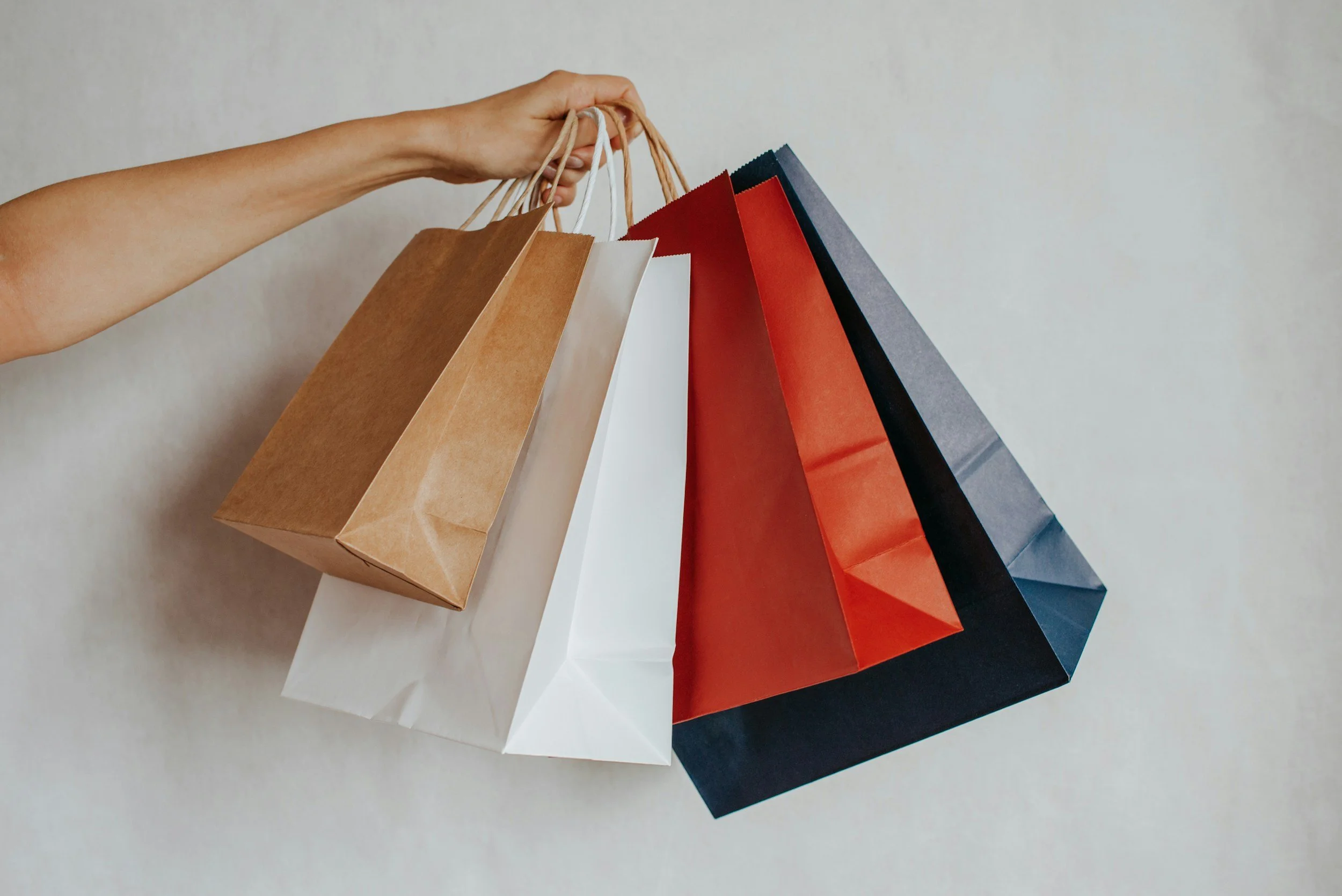 A hand holding out gift bags