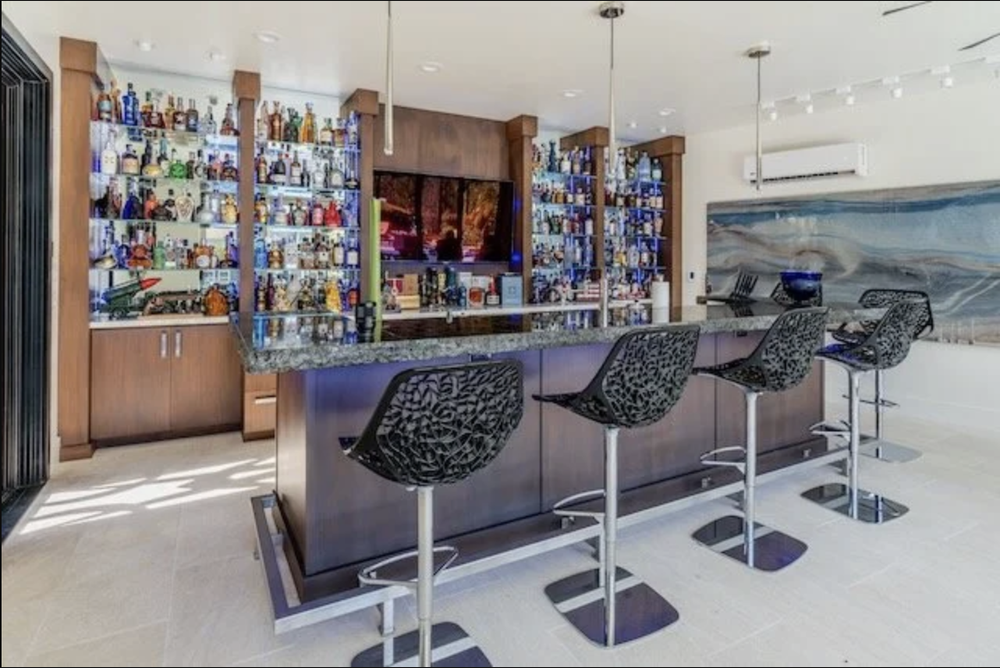 Custom built-in home bar with cabinetry, integrated storage, and countertop