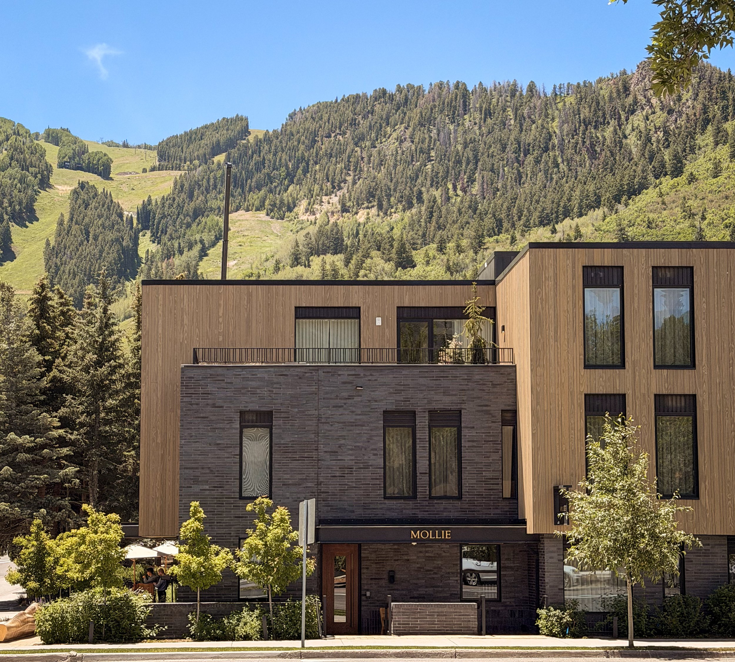 exterior of Mollie hotel in Aspen Colorado with Aspen mountain in the backgroung