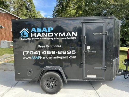 Custom black enclosed trailer graphics and vinyl lettering installation by a mobile sign shop serving Charlotte NC