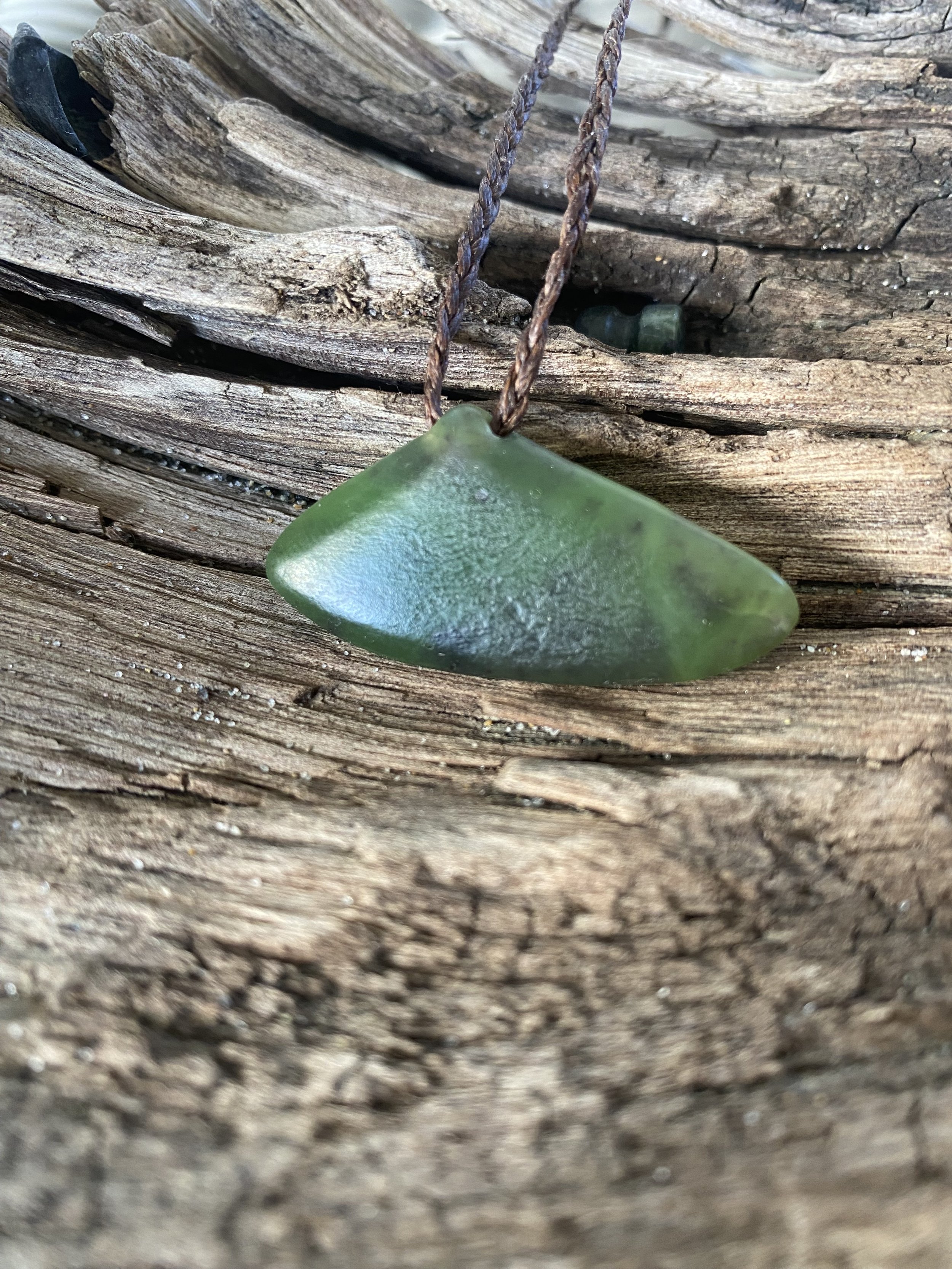 Hand carved Kawakawa pounamu pendant inspired by the form of a New Zealand tuatua shell, part of the MOANA collection by Amie Redpath.