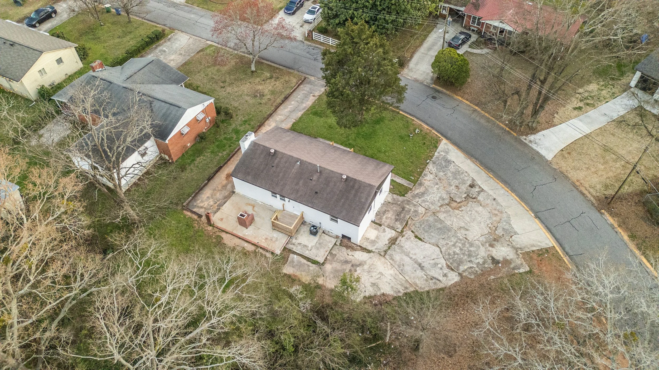 Aerial view of suburban neighborhood with houses in Athens, GA with trees, and a curving street.
