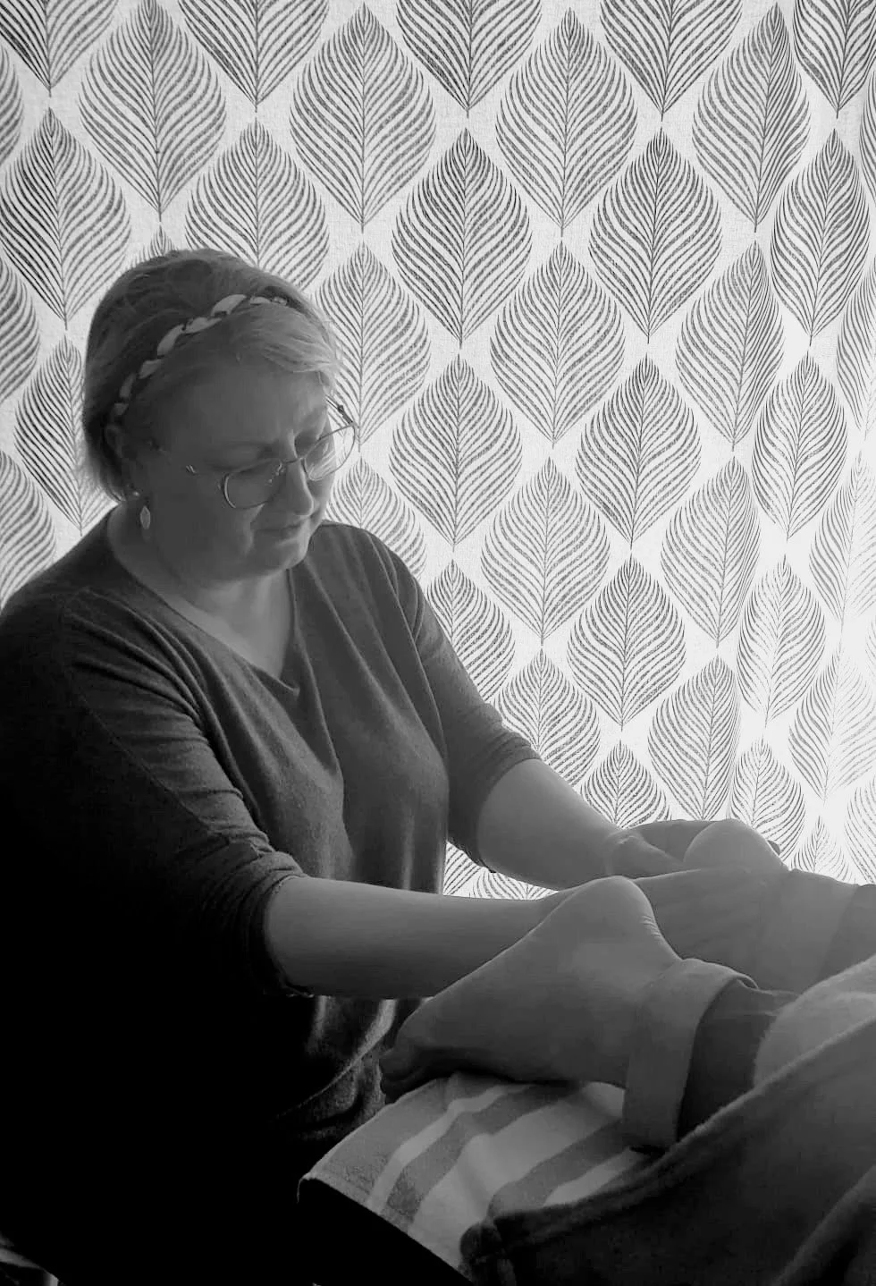 Chrystèle, la praticienne, qui termine le massage aux huiles essentielles sur la voute plantaire après avoir fait le dos.