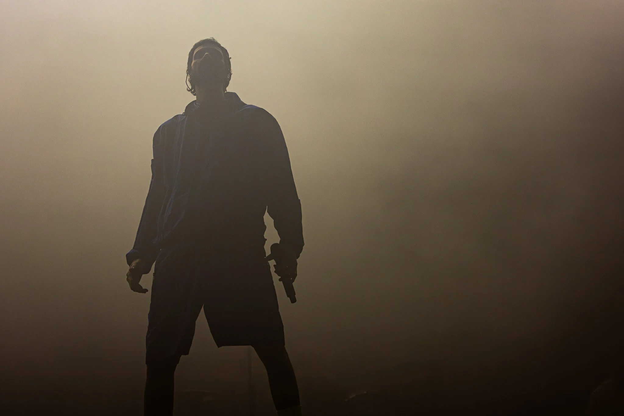 Serge Pizzorno stand silhouetted against a back drop while playing live with Kasabian at Latitude Festival Suffolk 2024