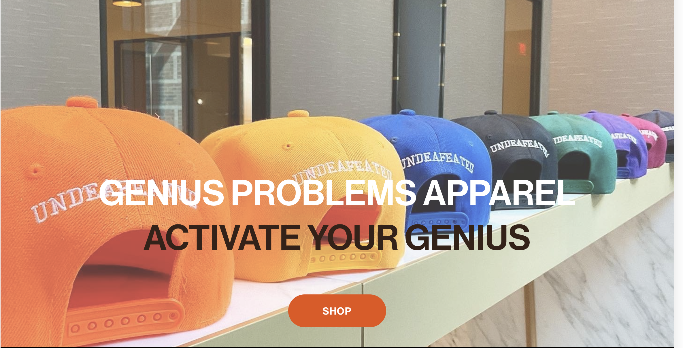 Colorful caps with the text "UNDEFEATED" on display, promoting apparel that encourages activating your genius.