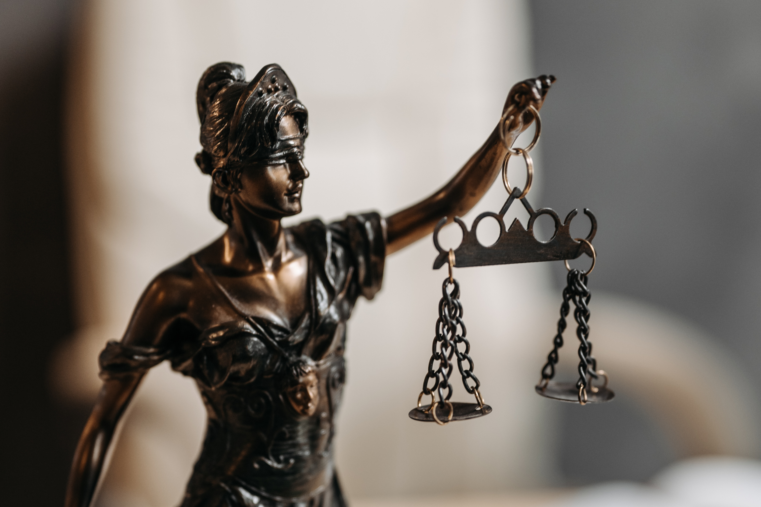 Bronze statue of Lady Justice holding a scale.