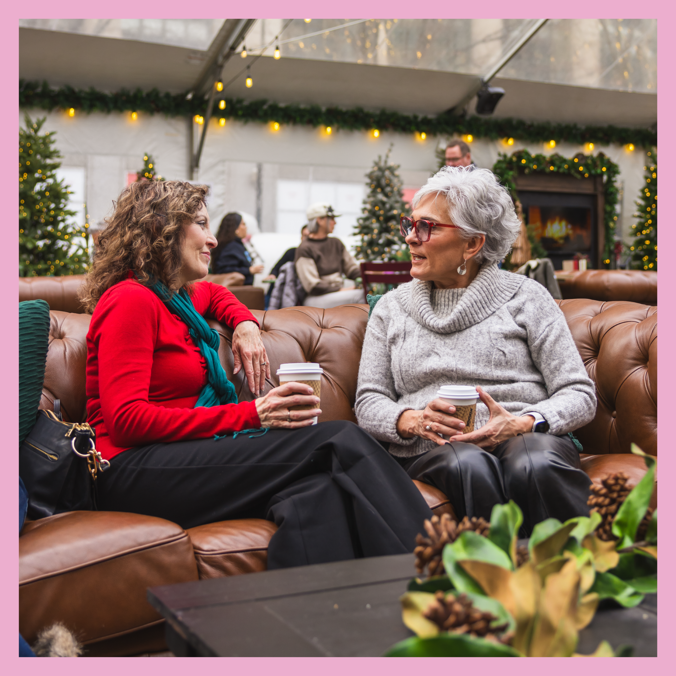 Two women sitting on a couch inside the Cadillac Lodge in downtown Detroit.