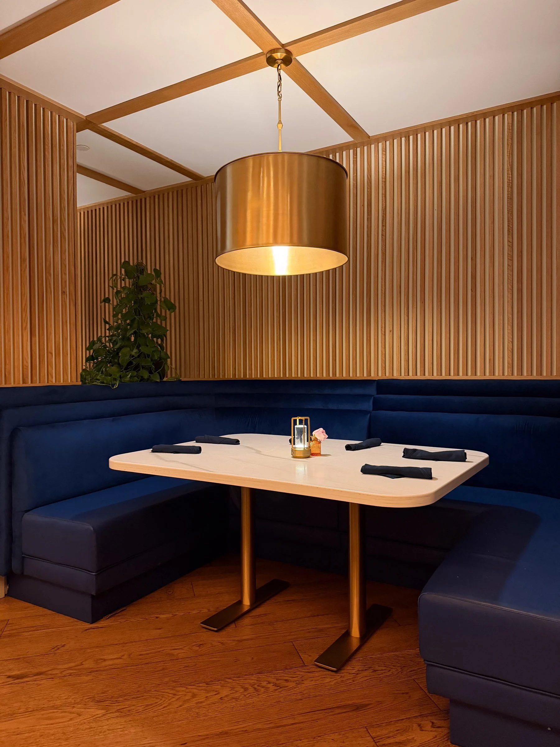 Interior of Eatori in downtown Detroit, featuring a blue seating area and dining table.