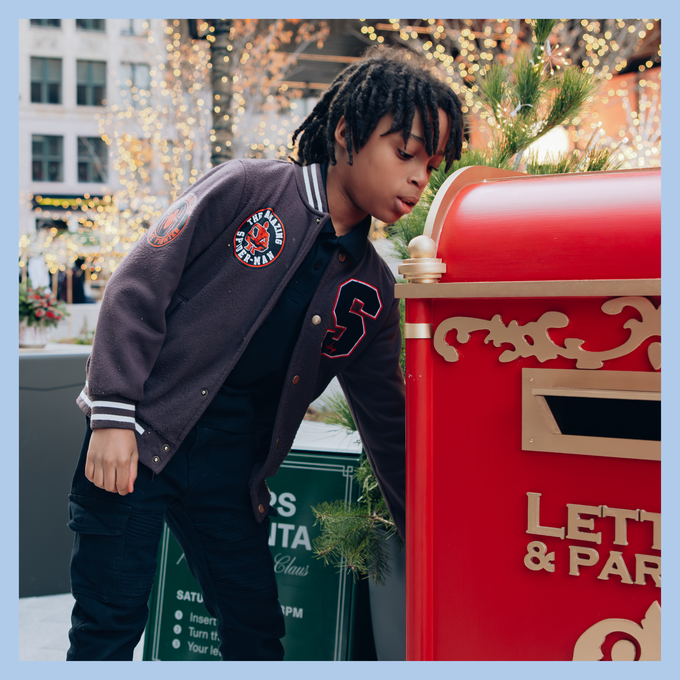 A visitor dropping off a letter at Santa's mailbox at Nick Gilbert Way in downtown Detroit.