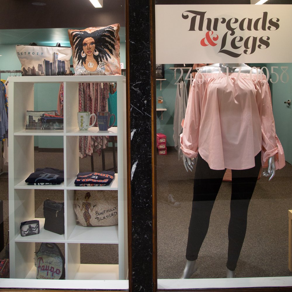 Exterior of Threads & Legs featuring various products on display, including a top and leggings on a mannequin.