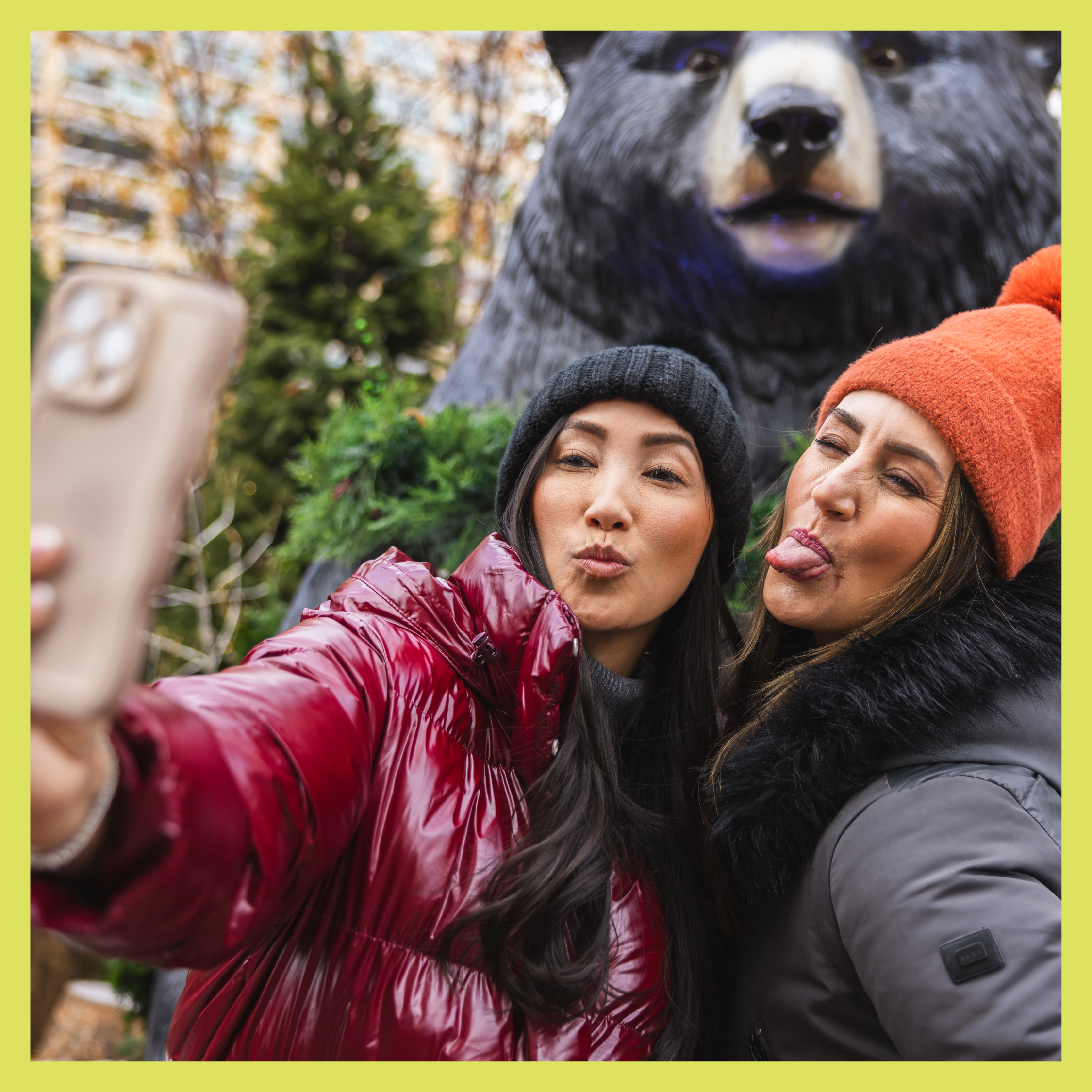 Visitors to downtown Detroit taking a selfie in front of a bear statue.