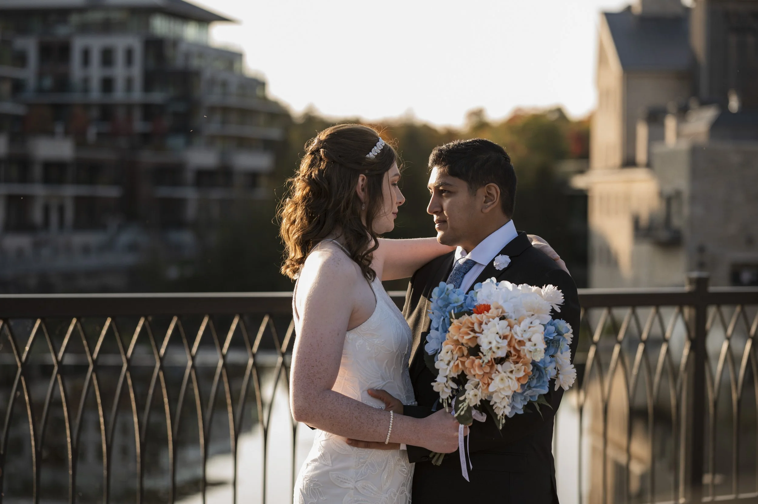 Bride and groom sharing a quiet moment by the waterfront at Elora Mills 
