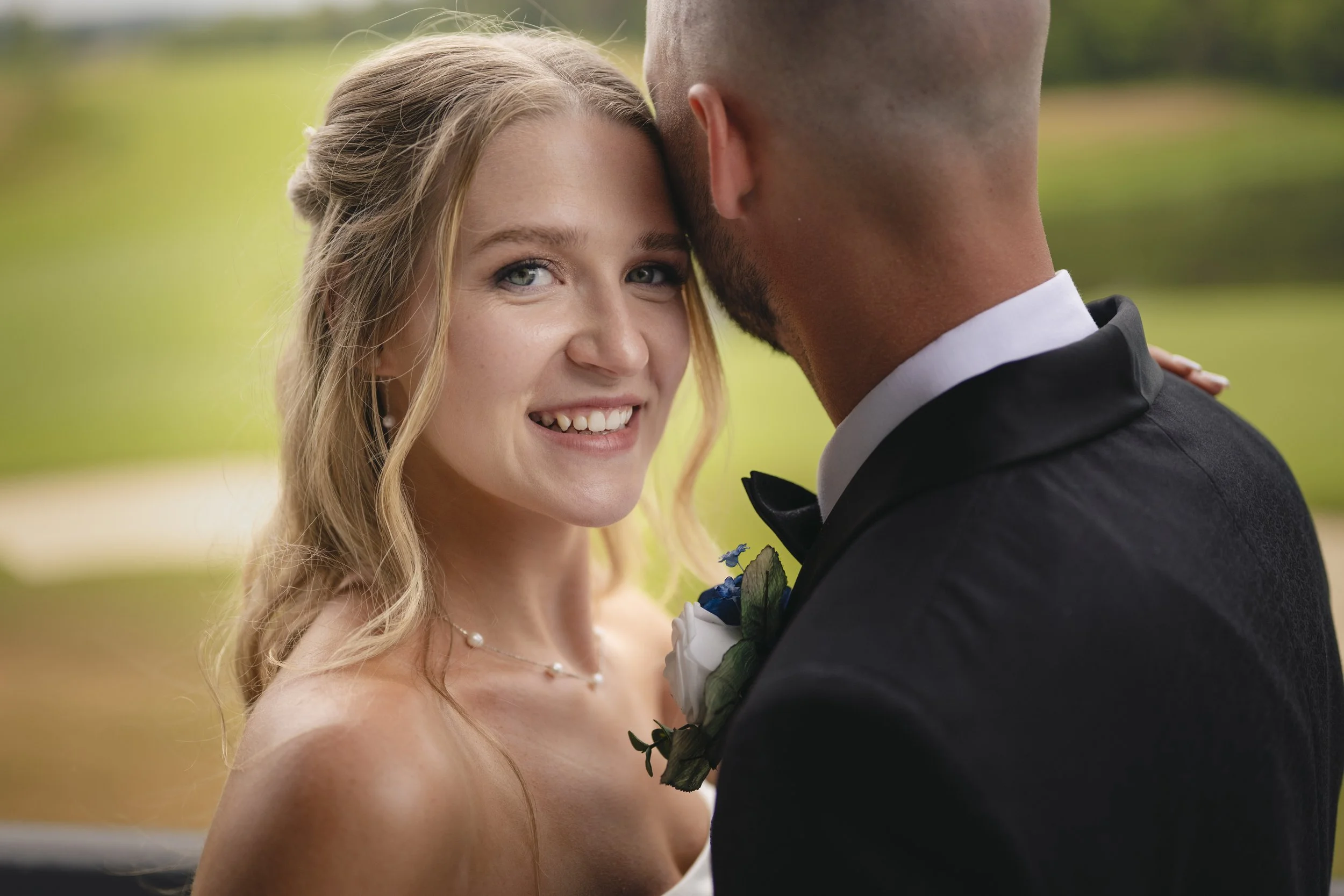Bride smiling at the camera during portrait session with groom at TPC Toronto Osprey Valley golf club and event space