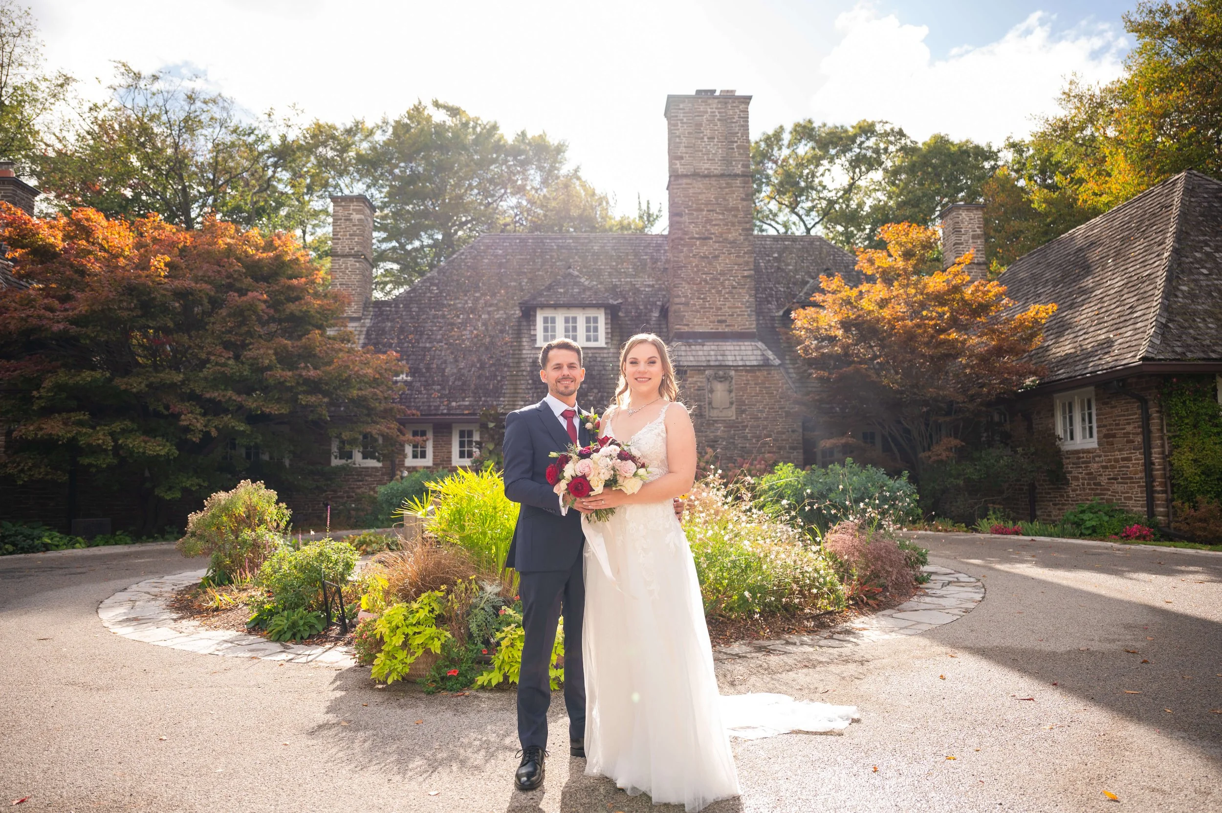 Bride and groom posing for portraits in front of a historic Mississauga venue.