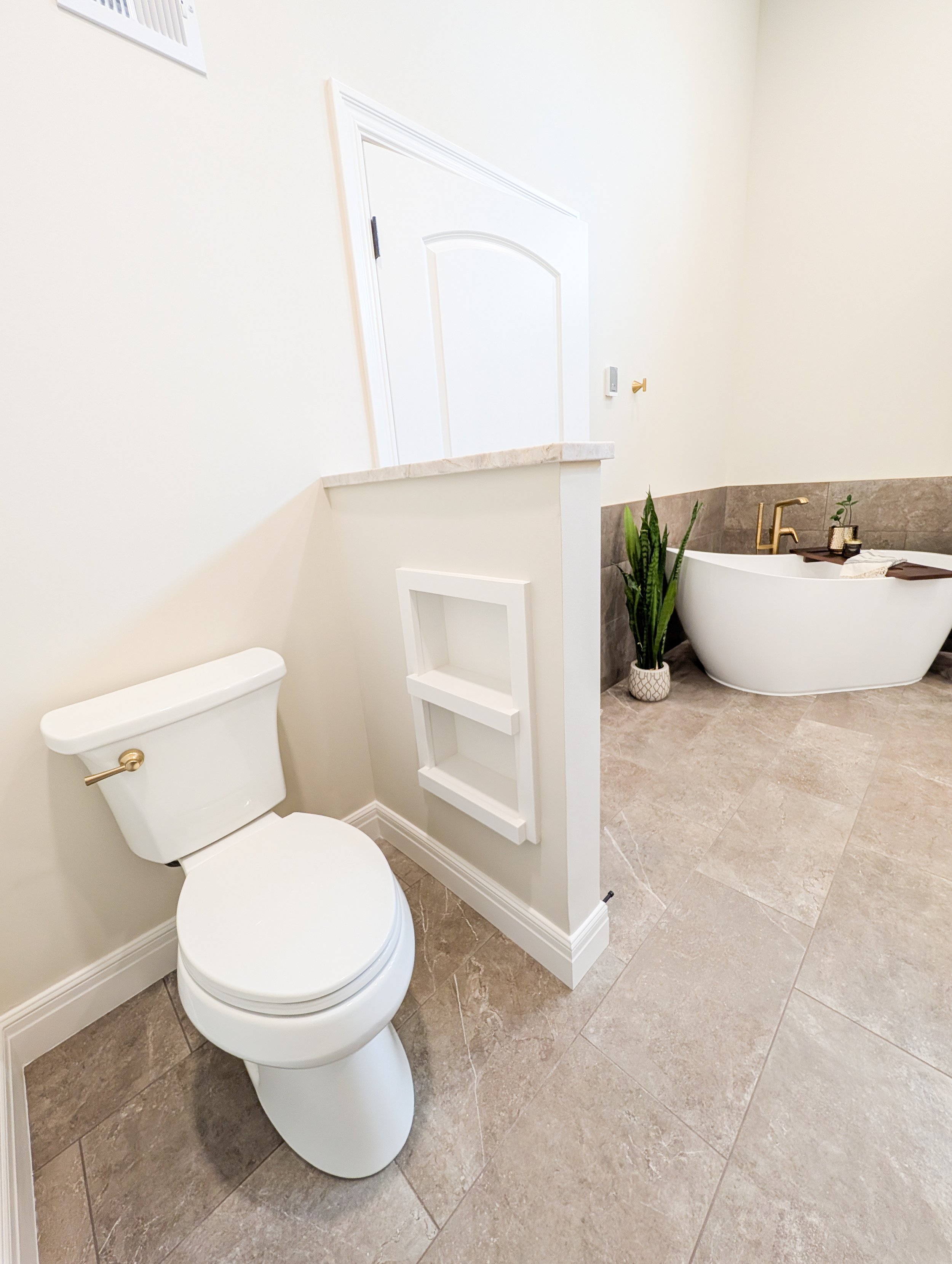 Updated water closet with toilet paper and toiletries niche