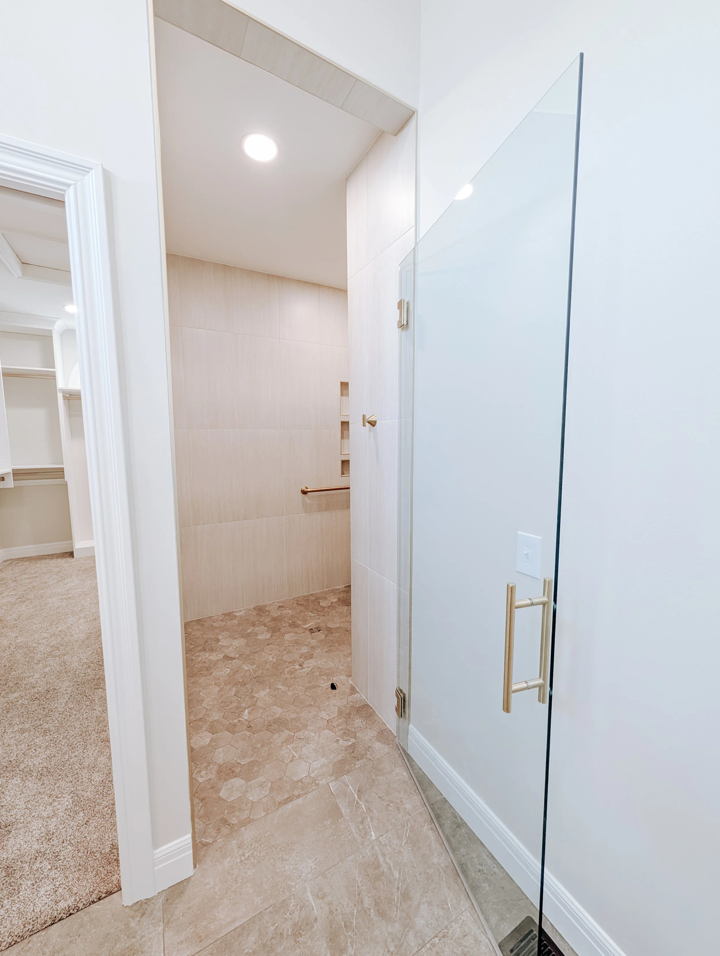 Lee's Summit bathroom remodel with walk in shower, custom glass shower door, gold accents and heated tile floors