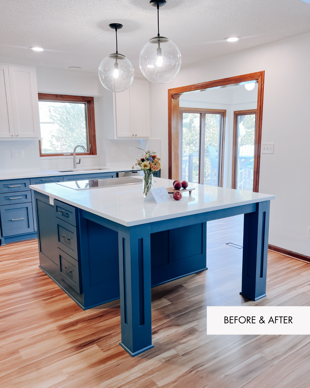 After of a Lakehouse kitchen remodel in Lee's Summit with pendant lights, blue cabinetry, new flooring and a beautiful convection stovetop