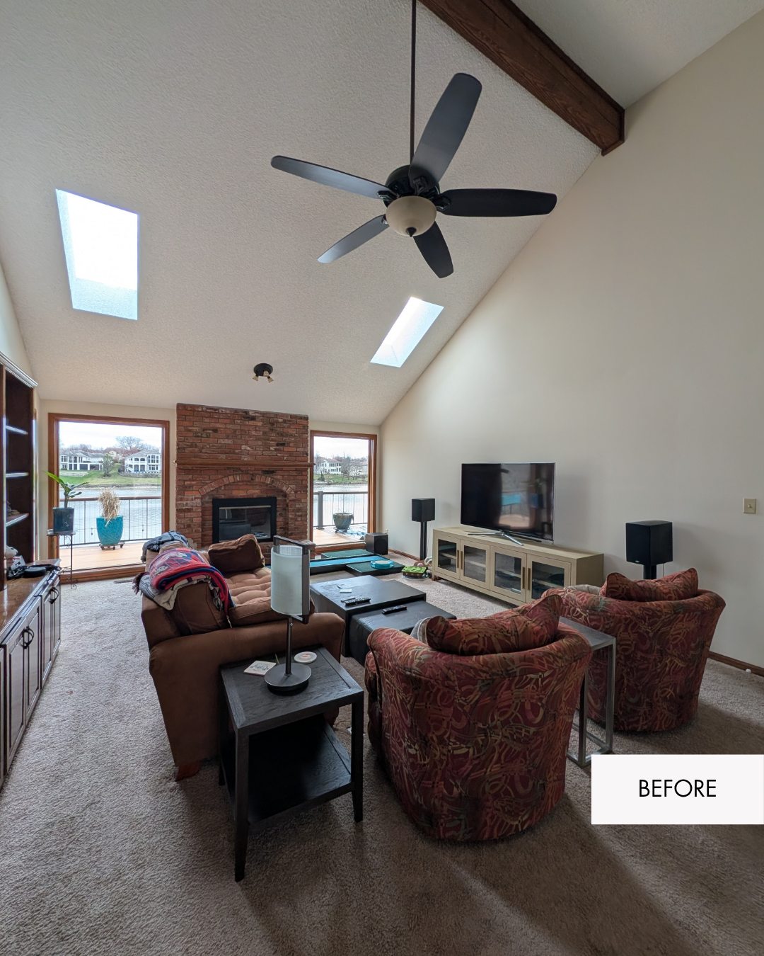 Before photo of a Lee's Summit living room with mismatched furniture, a dated ceiling fan and old carpet