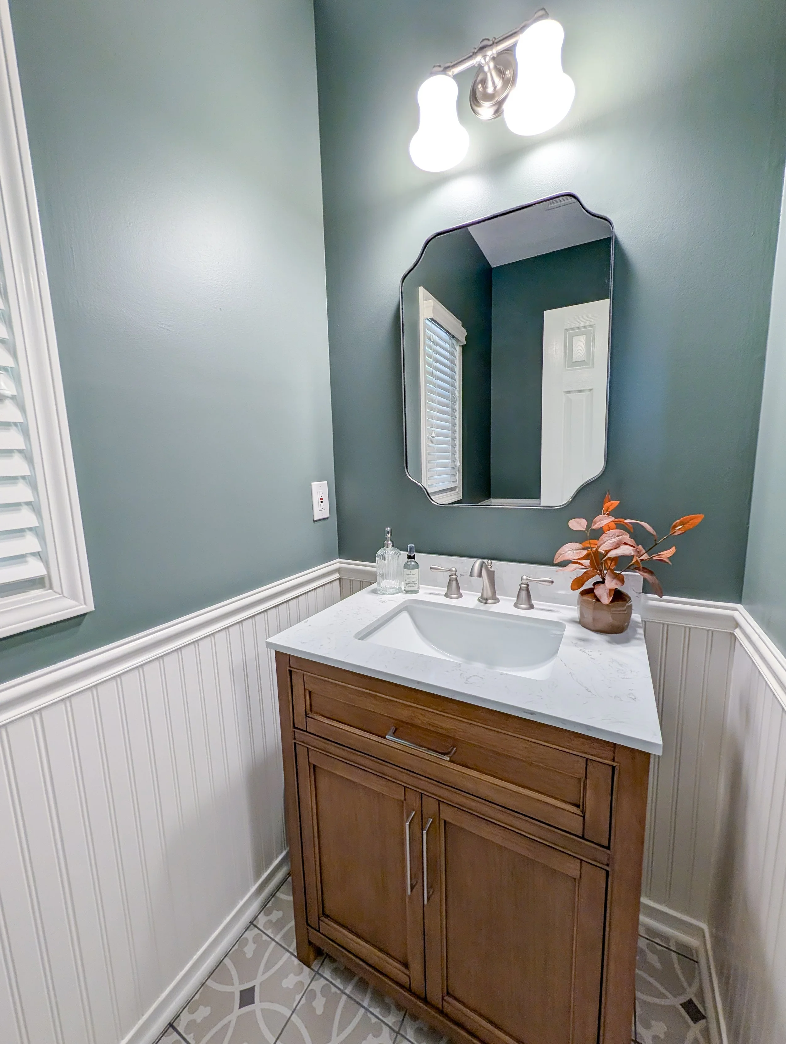 After photo of remodeled Lee’s Summit powder bathroom with SW Retreat walls, new vanity, and patterned floor tile.
