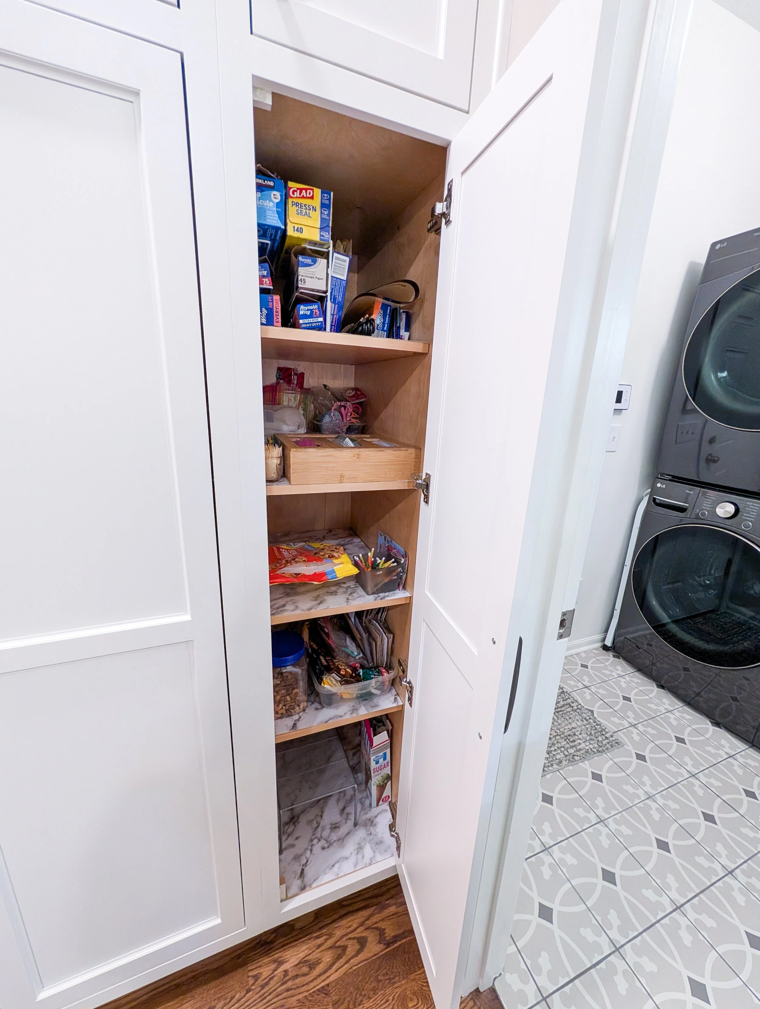 After photo of remodeled Lee’s Summit kitchen featuring white cabinets and additional pantry space and shelves