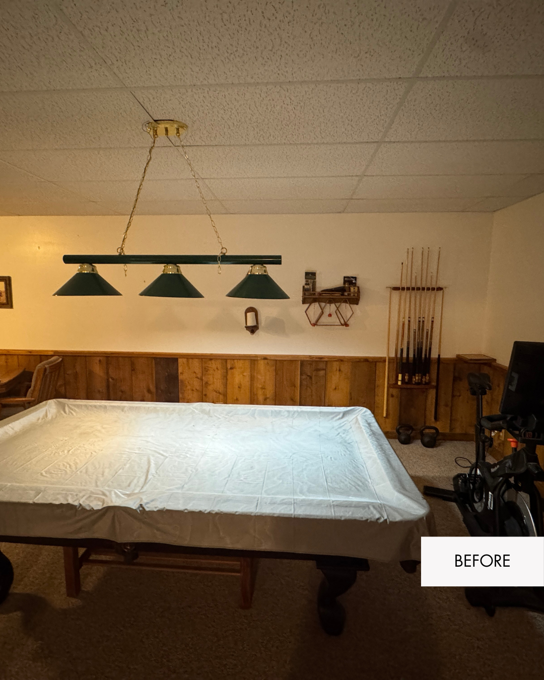 Basement game and workout area before remodel in Grain Valley MO with drop ceiling and dated lighting