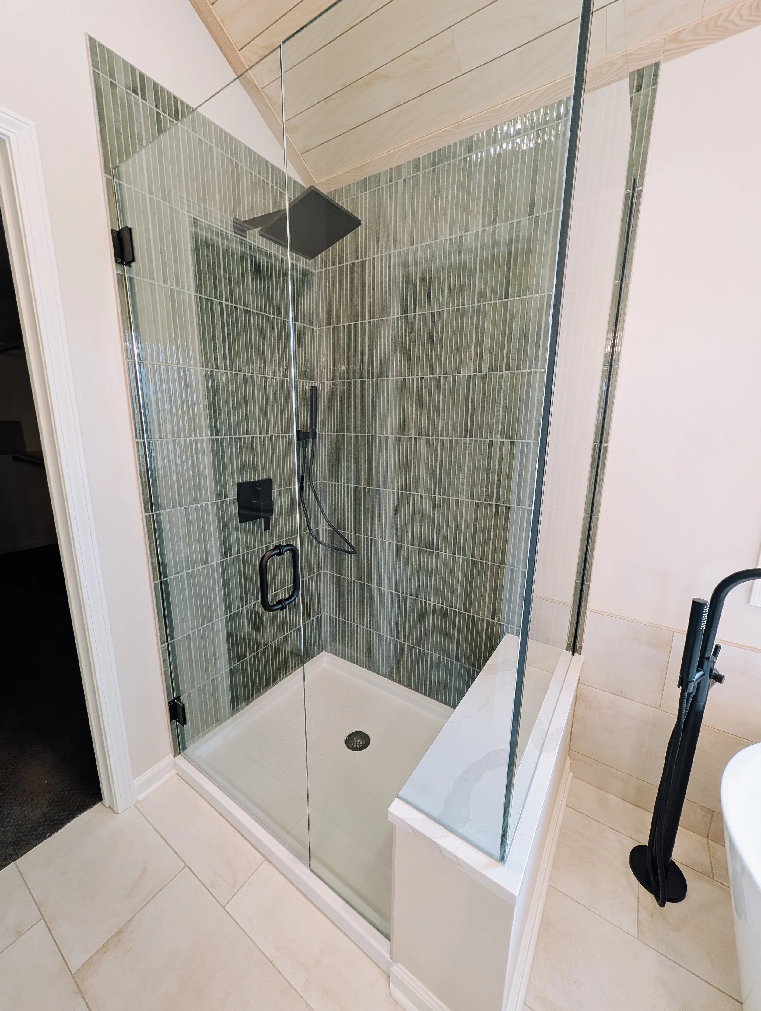 Lee's Summit bathroom remodel with custom glass corner shower, green wall tile and custom bench