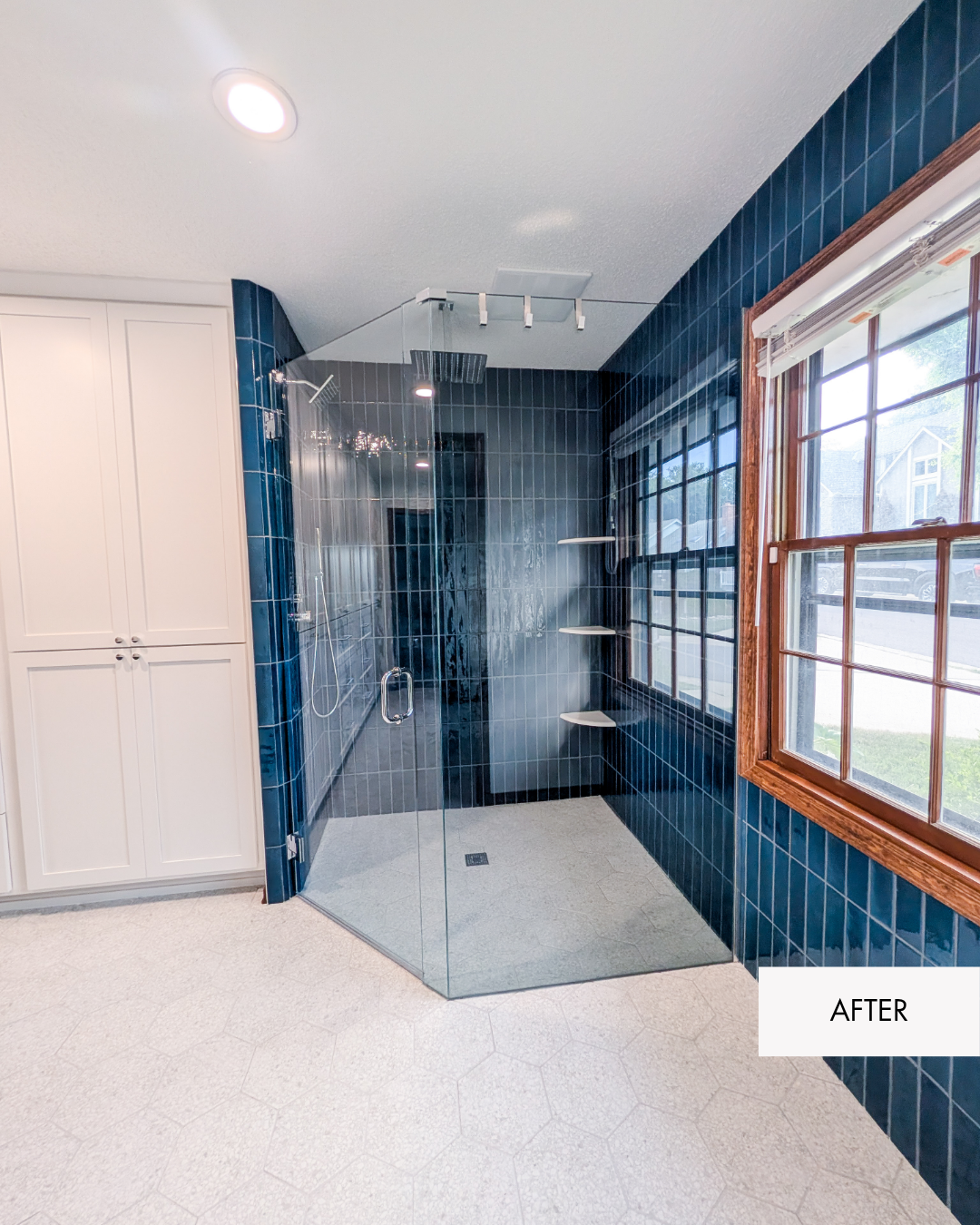 Large walk-in shower in the remodeled primary bathroom, built in the former bathtub location with updated blue shower tile and modern fixtures