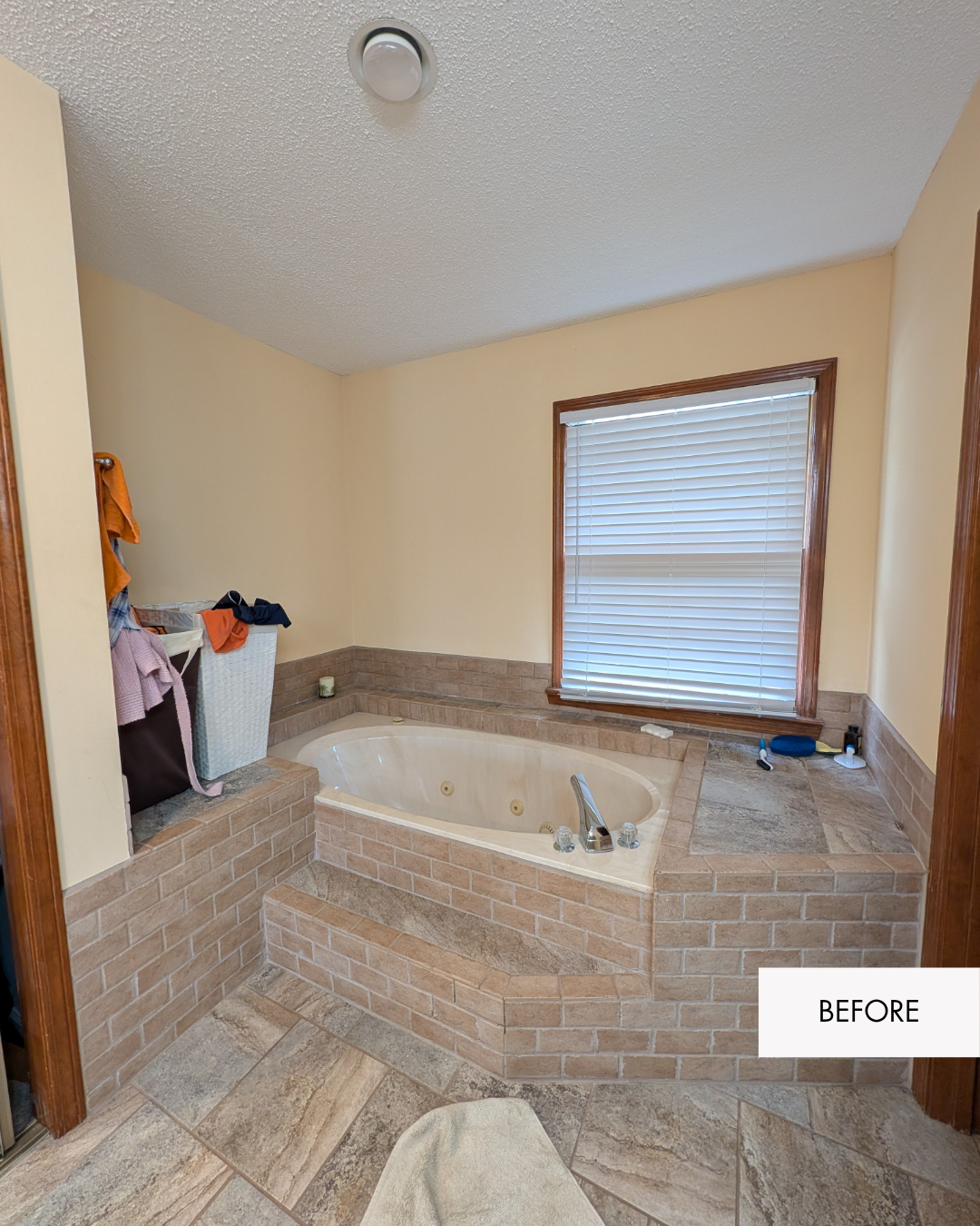Primary bathroom before remodel with yellow walls and a large jetted bathtub taking up the main bathroom space