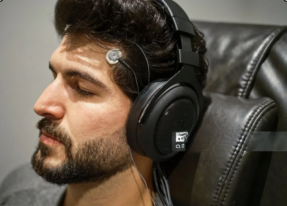 Man wearing an EEG neurofeedback sensor and headphones during a relaxing neurofeedback session at The Resiliency Co.