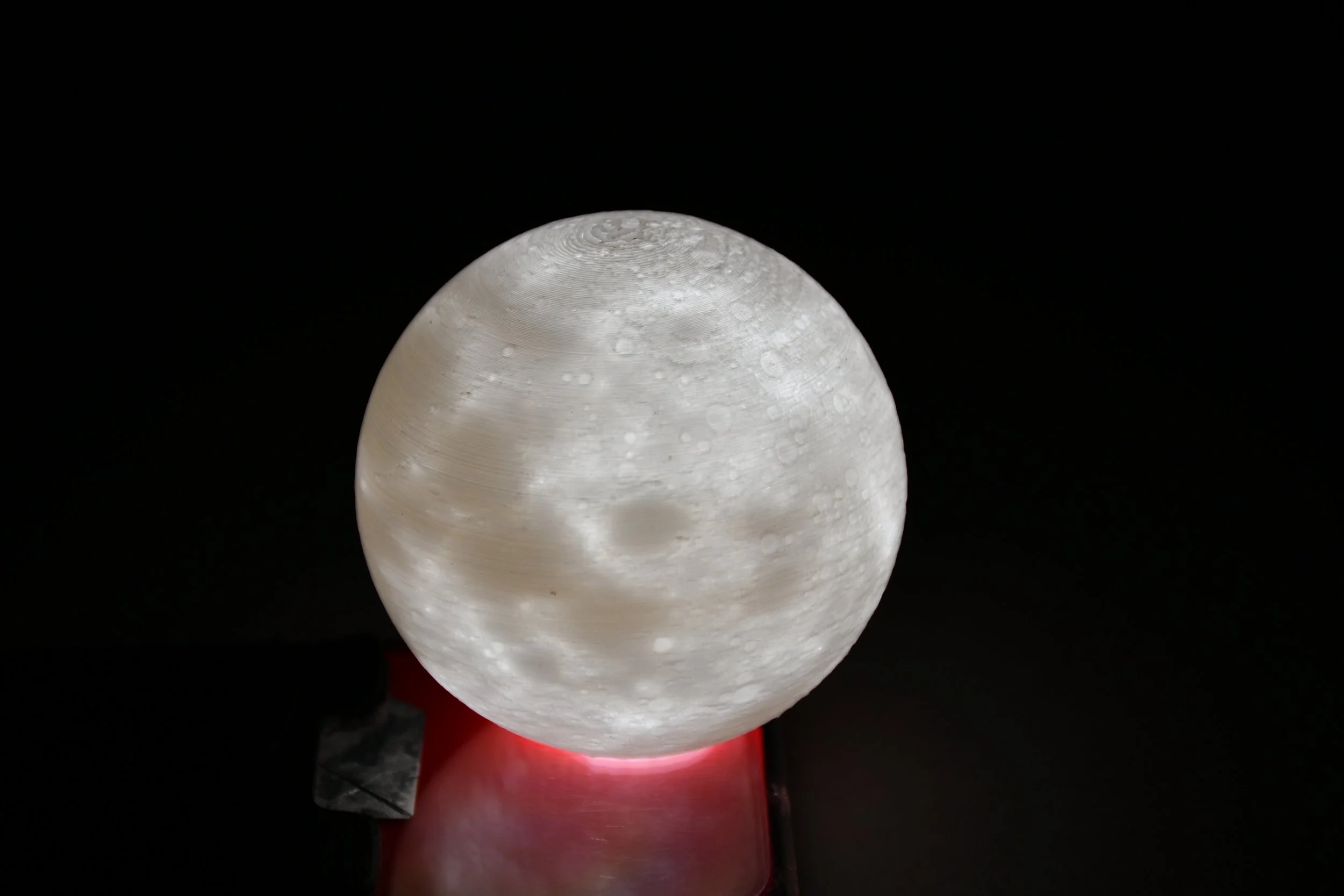 Because the wall width varies, the sphere acts as a lithophane when light is shone through it, creating a very crisp image of the moon's surface.
