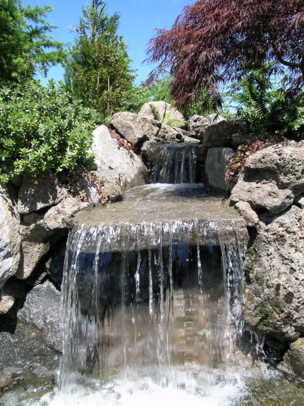 A natural stone, man-made waterfall installation completed by Big Sky Landscaping for a client in Happy Valley.