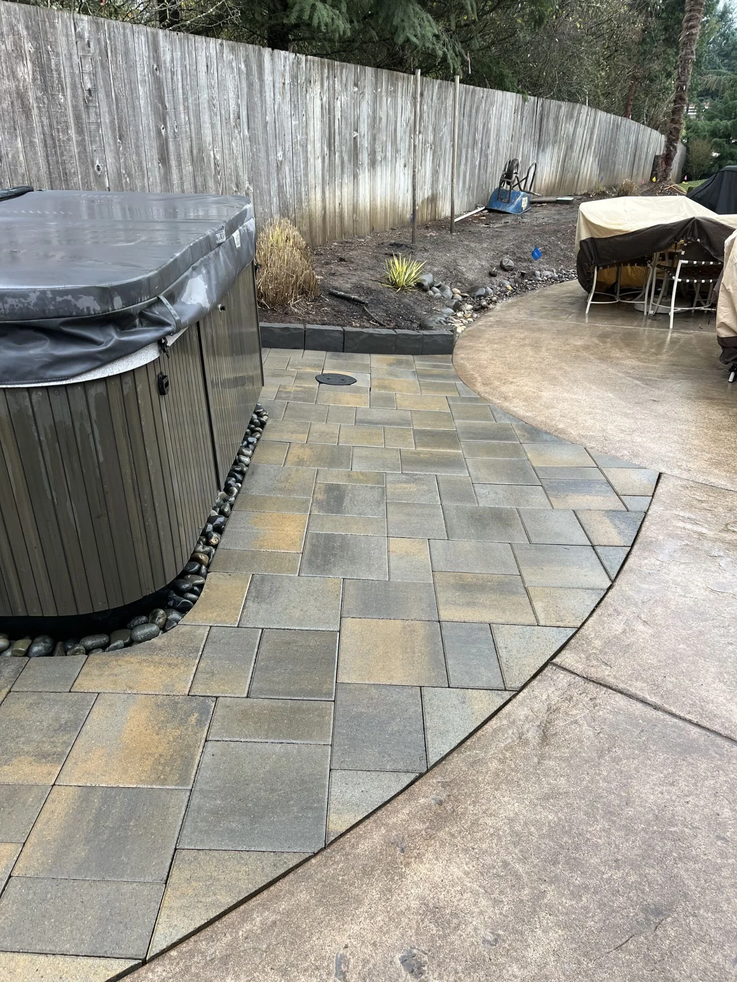 A hot tub and patio set sitting upon a newly installation patio.