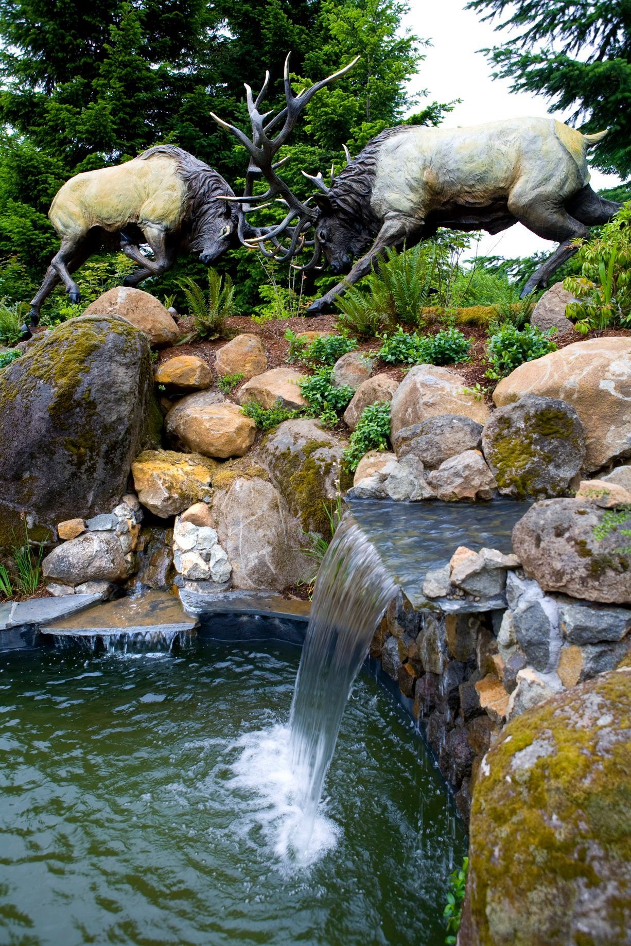 A close-up view of a natural rock waterfall and pond, adding a serene focal point to a beautiful Oregon City backyard.