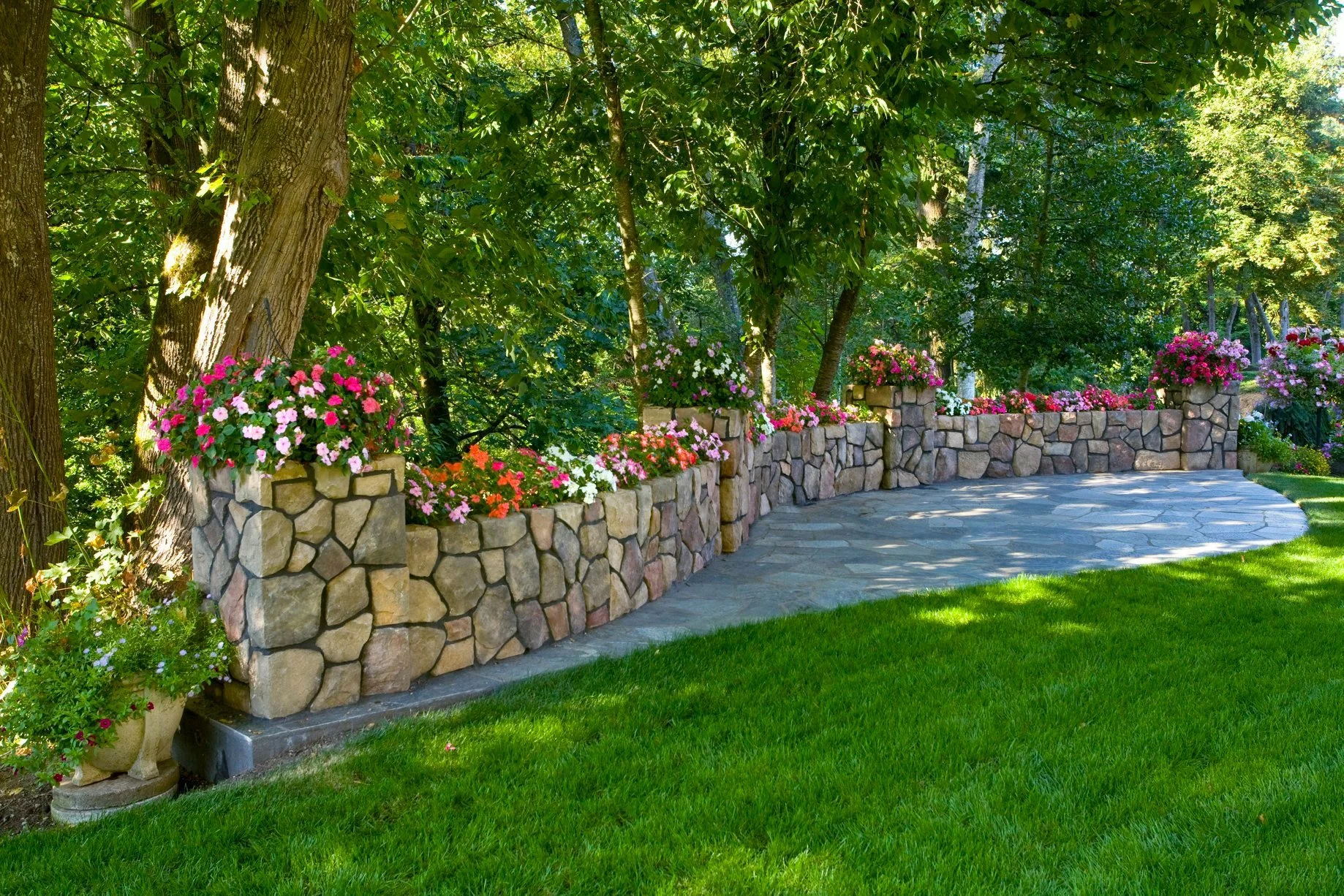 A decorative stone wall topped with colorful flower beds creates a stunning perimeter for this Oregon City lawn, installed by a local Oregon City landscaping company.