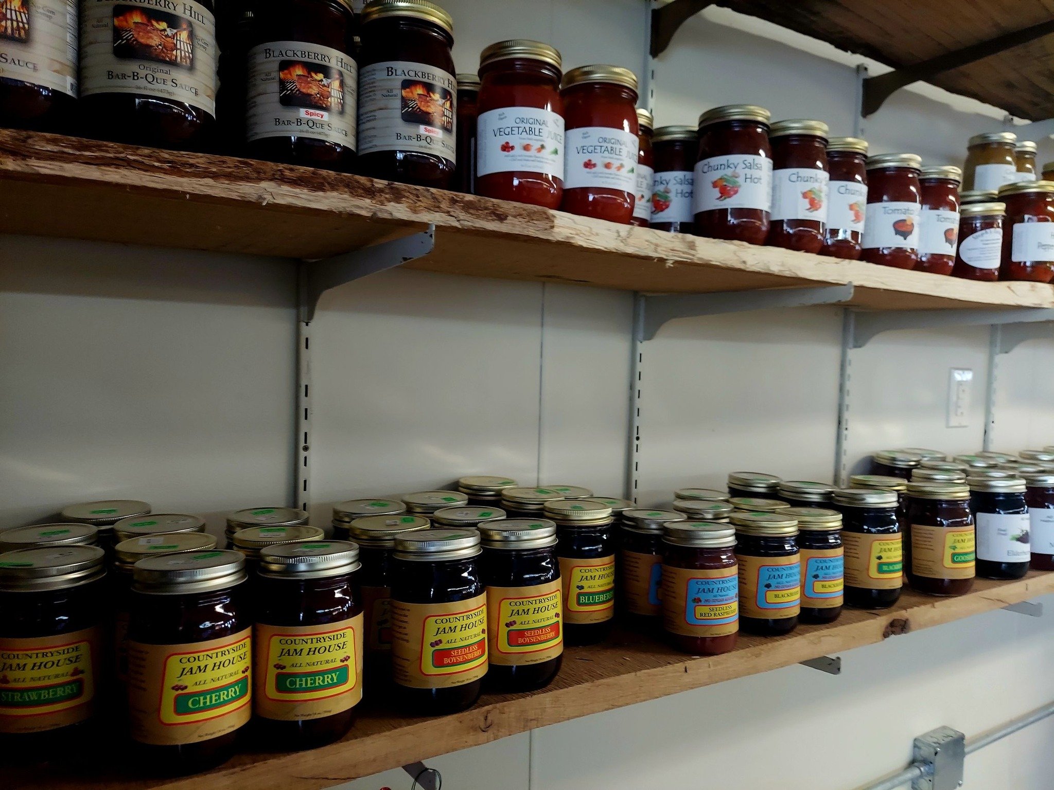 Shelves stocked with various jars of jam and sauces.