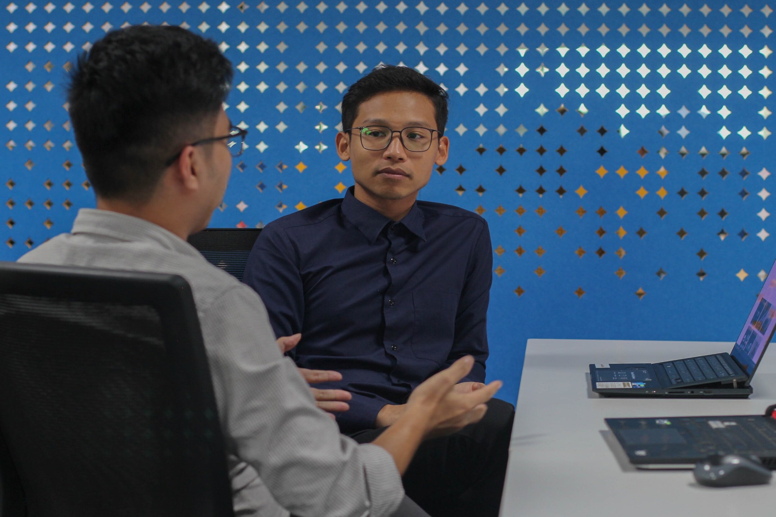 two people talking at a desk