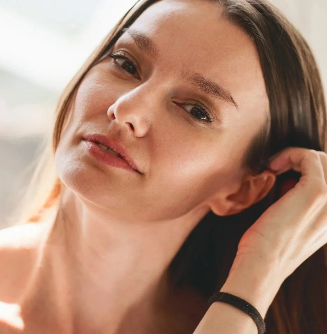 Middle aged woman brushing hair behind her ear