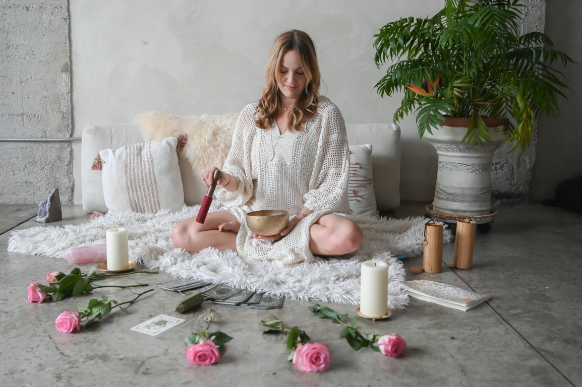 Lotem Porat seated with singing bowls and sound instruments.