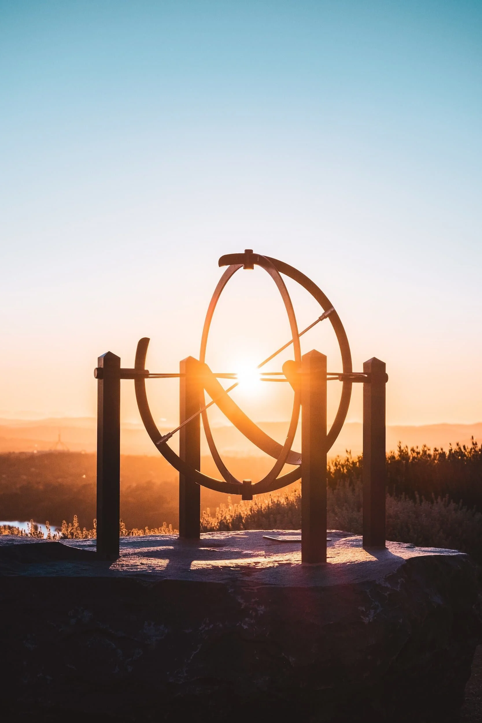 Sunset at top of mountain viewed through circular sculpture