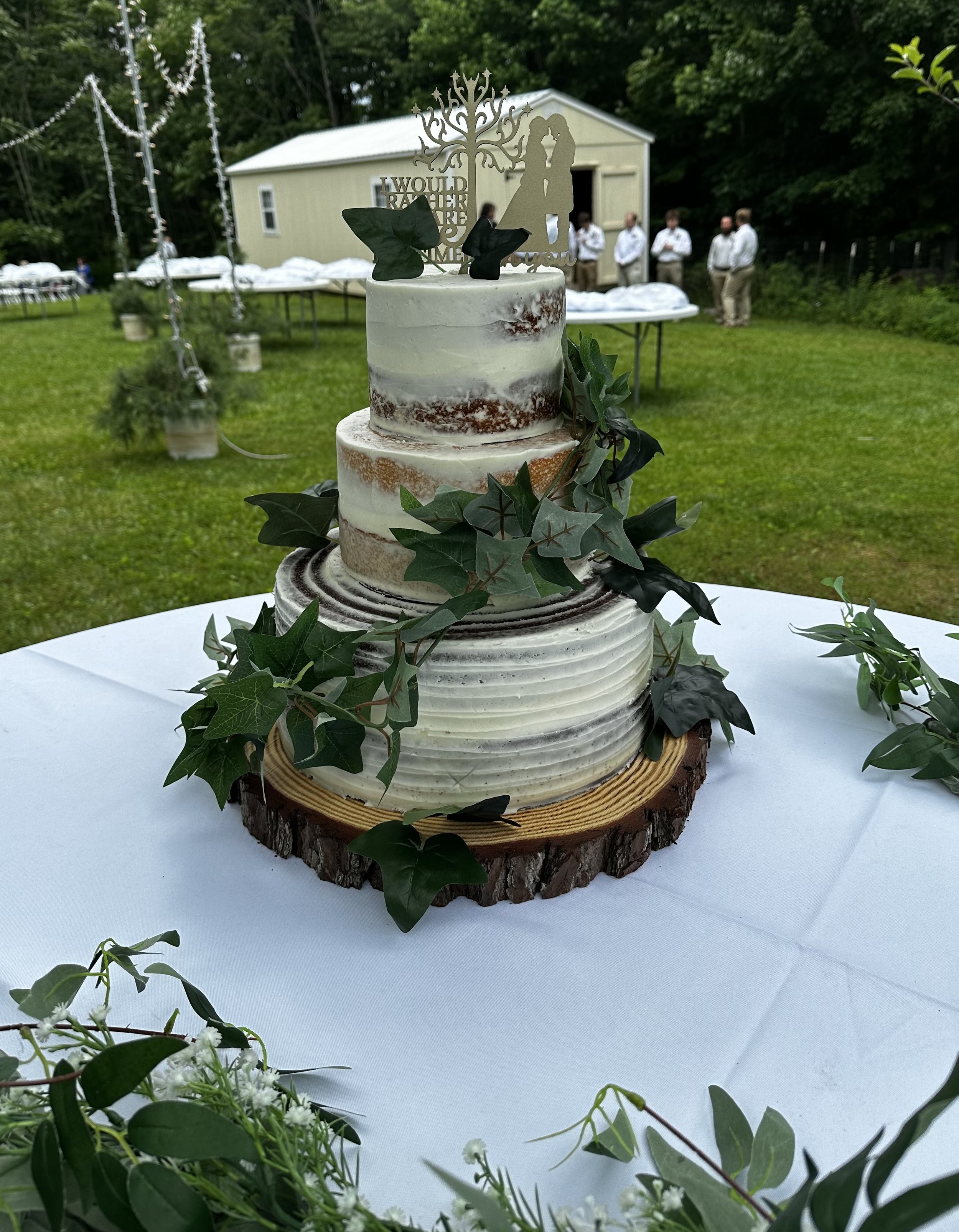 3 tier naked wedding cake with 3 flavors: chocolate, vanilla, and carrot cake; cream cheese flavored buttercream filling and frosting. Lord of the Rings themed wedding.