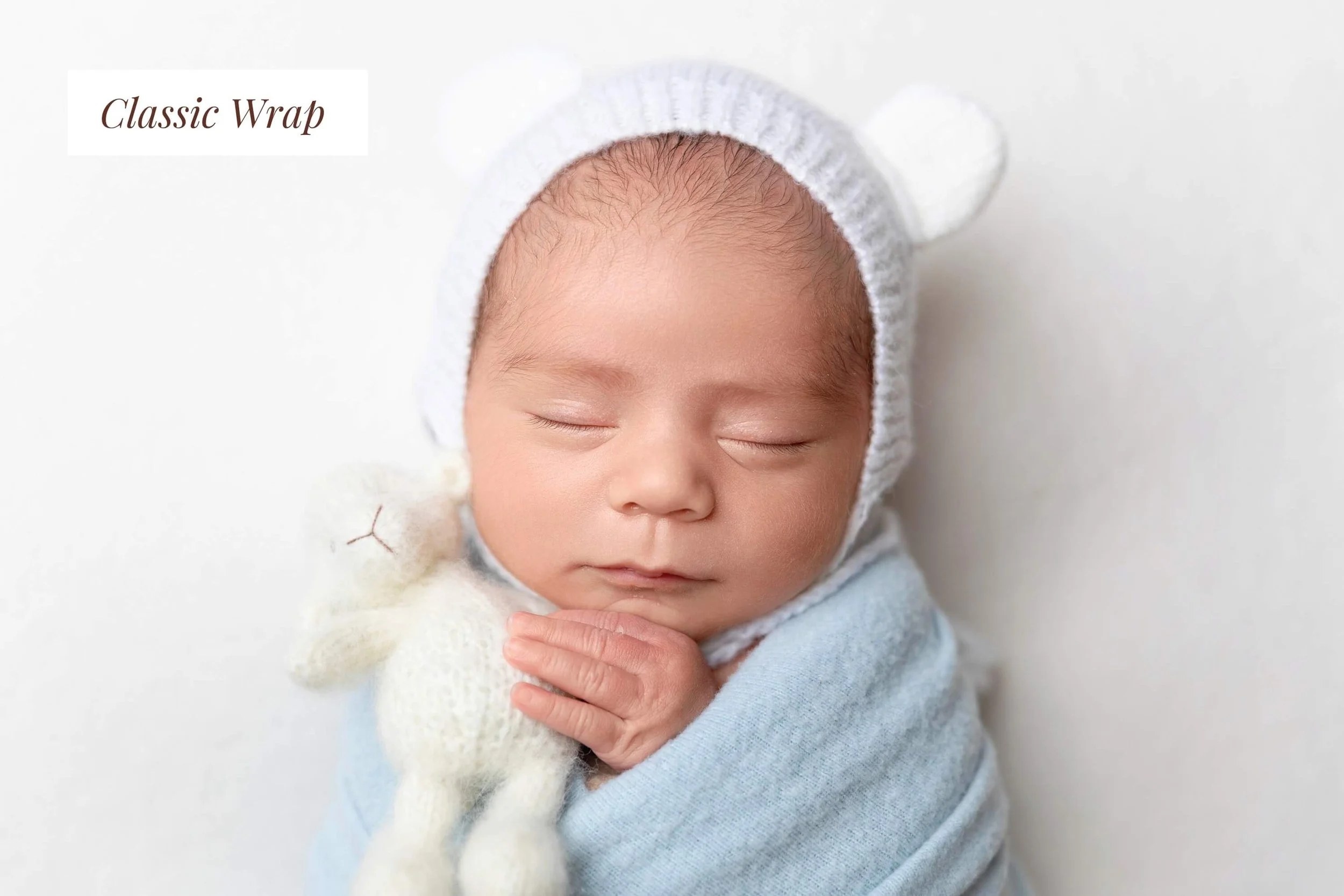 Newborn baby wrapped in blue in a studio setting