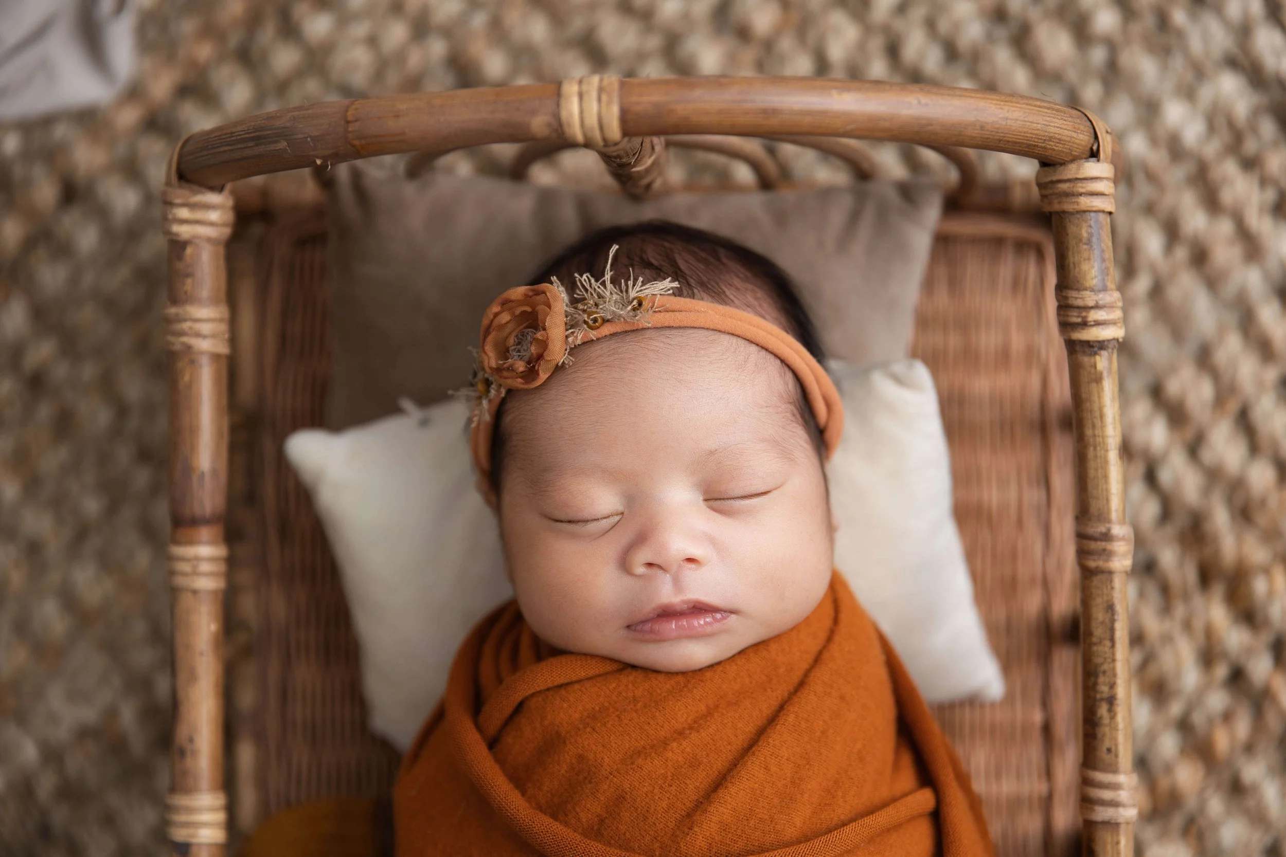 baby in basket in orange wrap