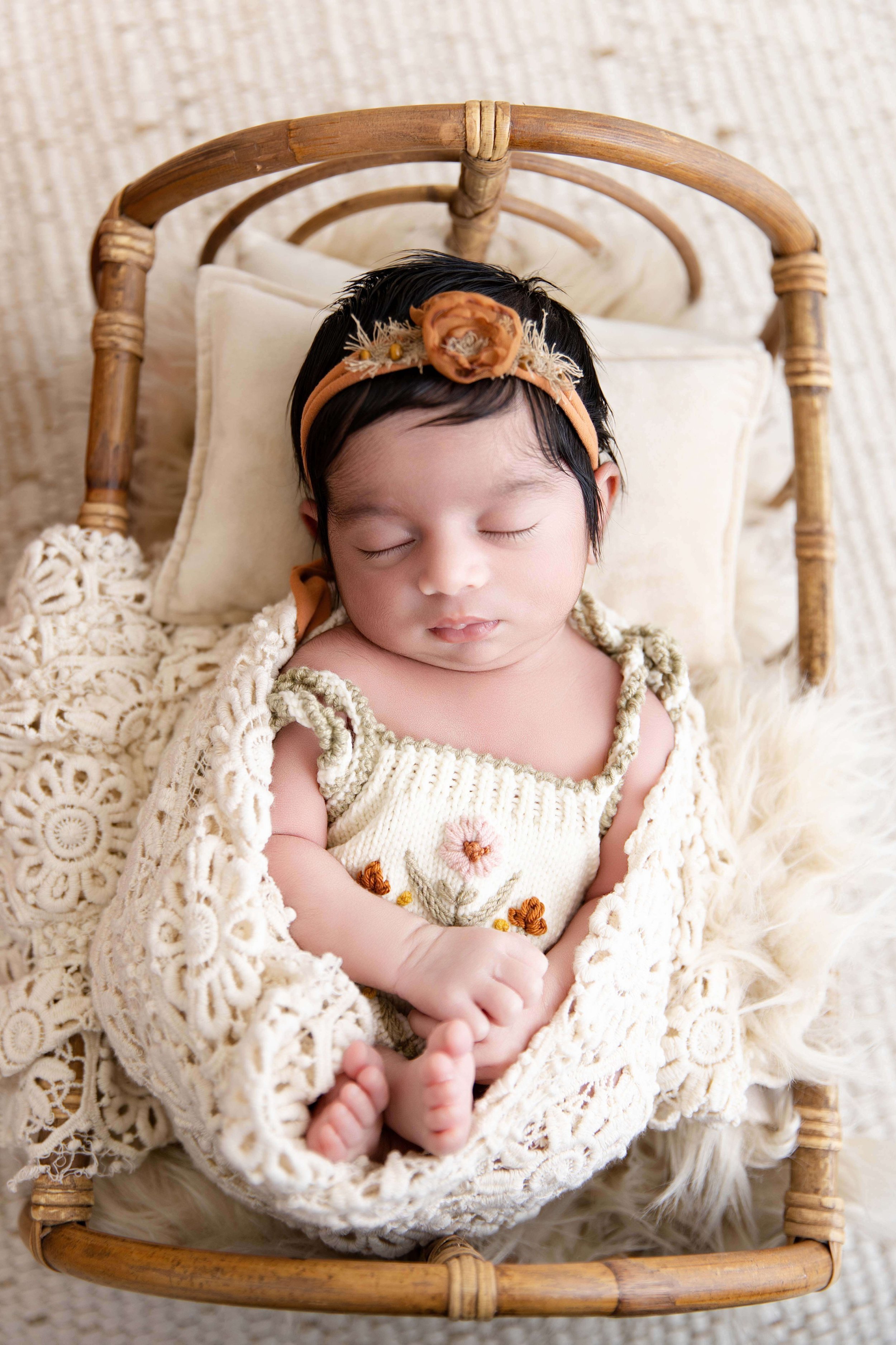baby wearing knitted outfit in basket