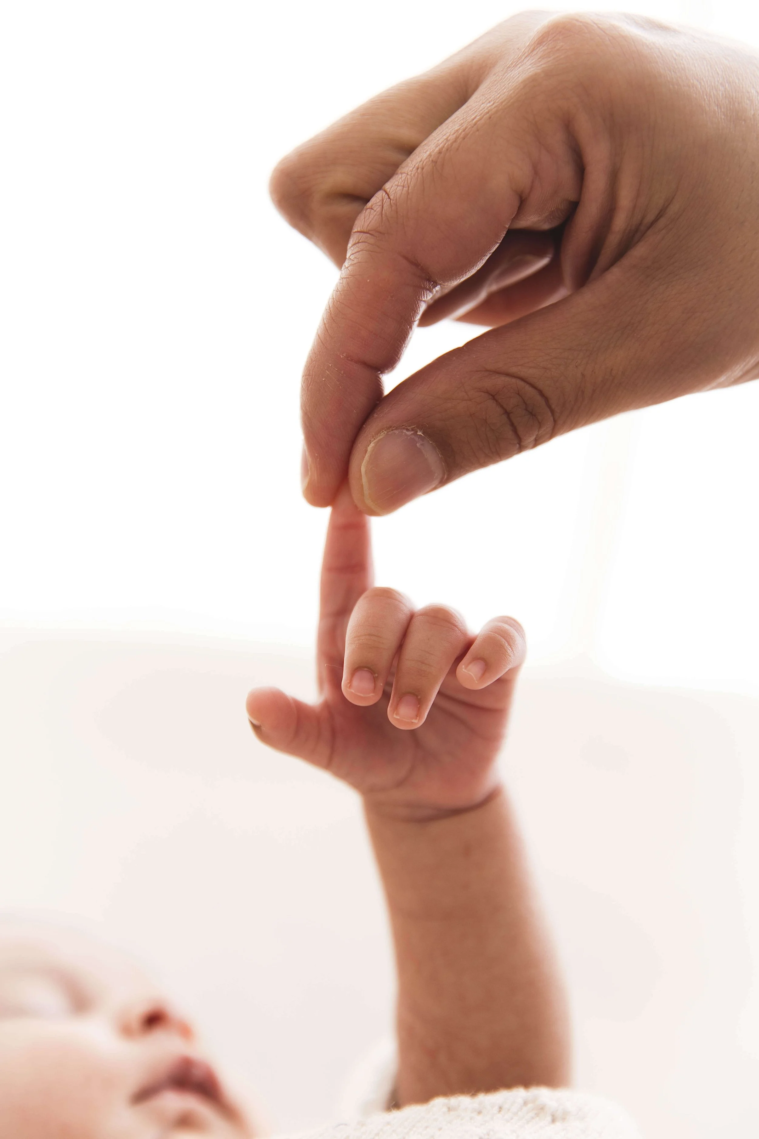 mom holding baby's finger