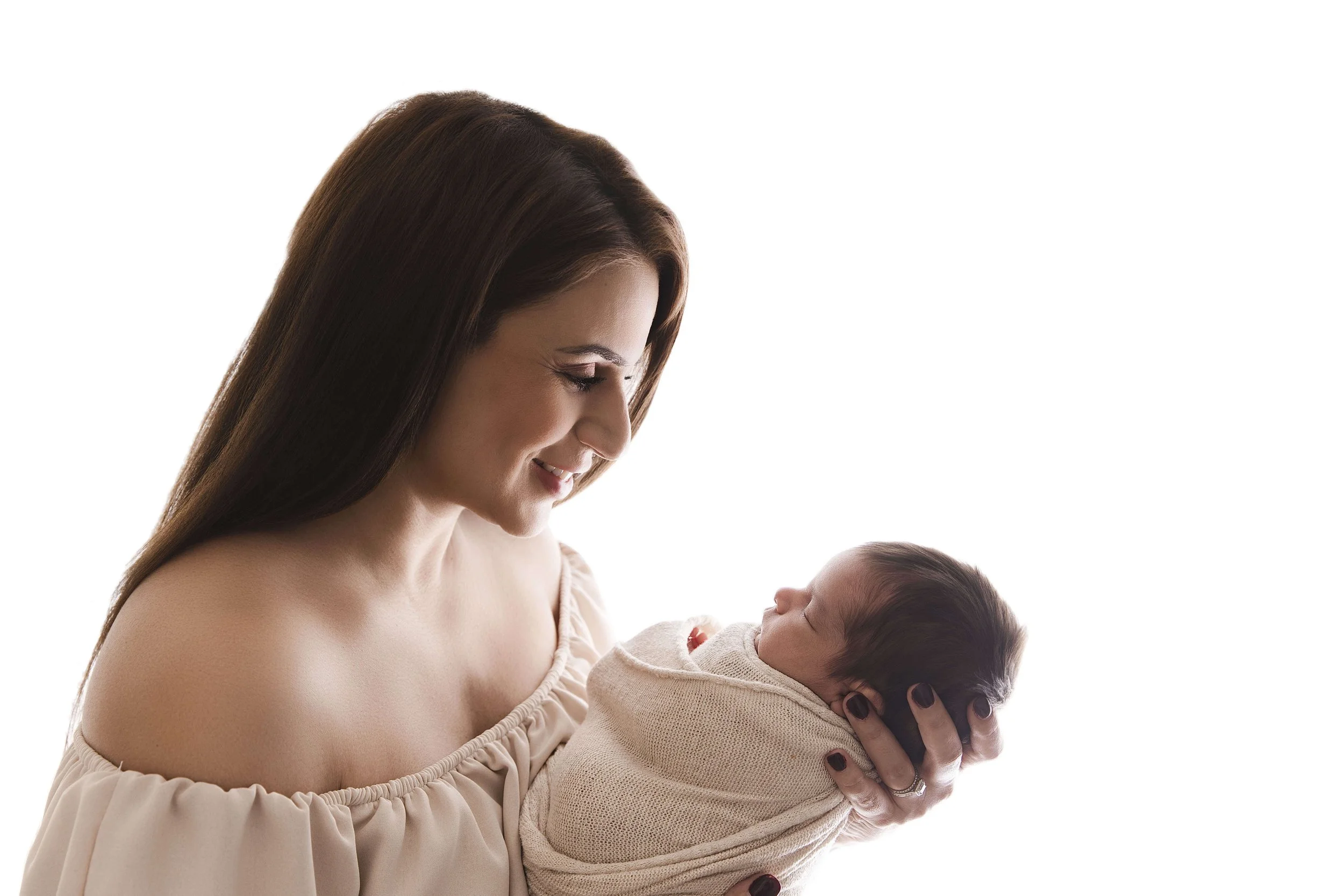 beautiful mom looking down at her newborn