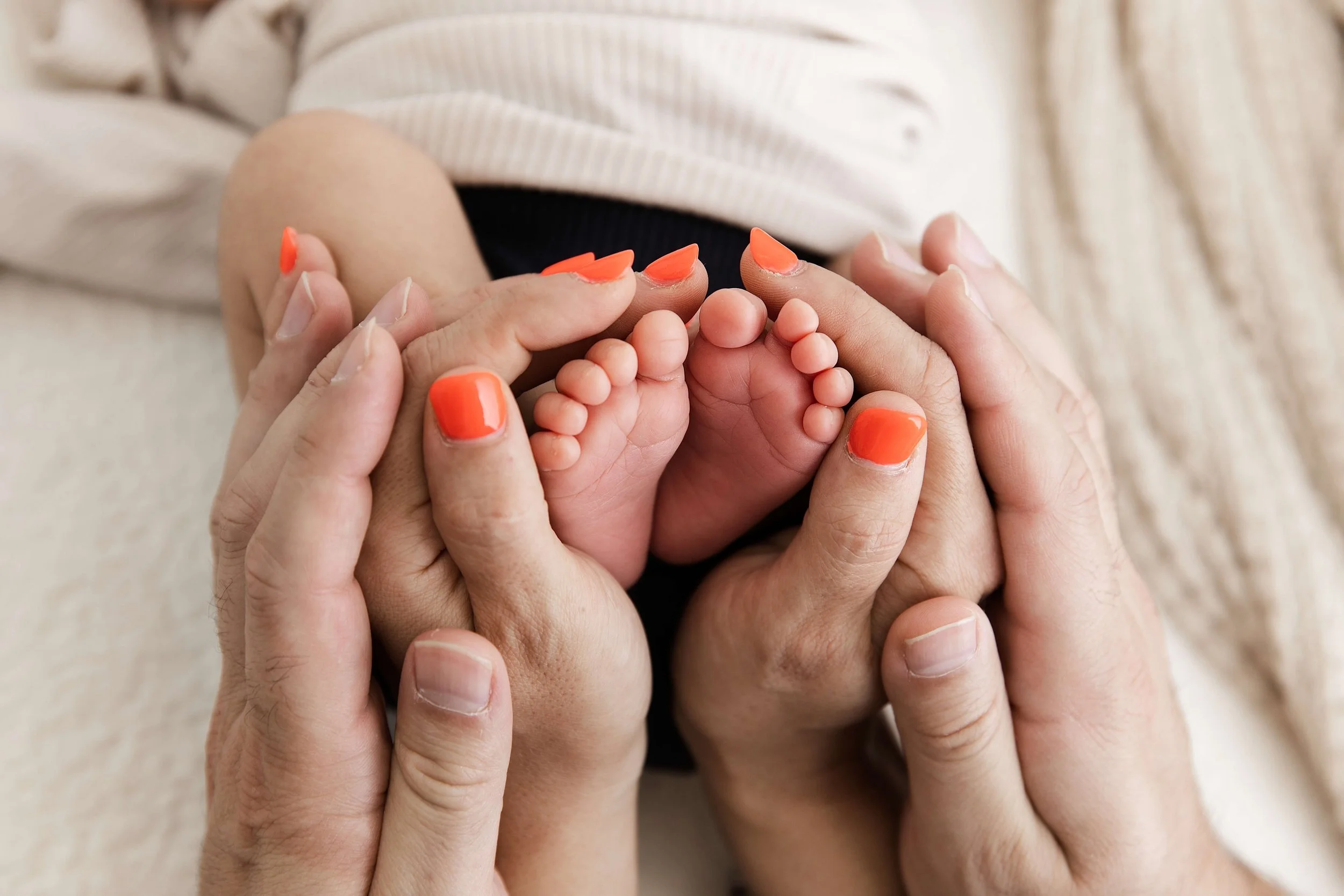 parents holding baby feet