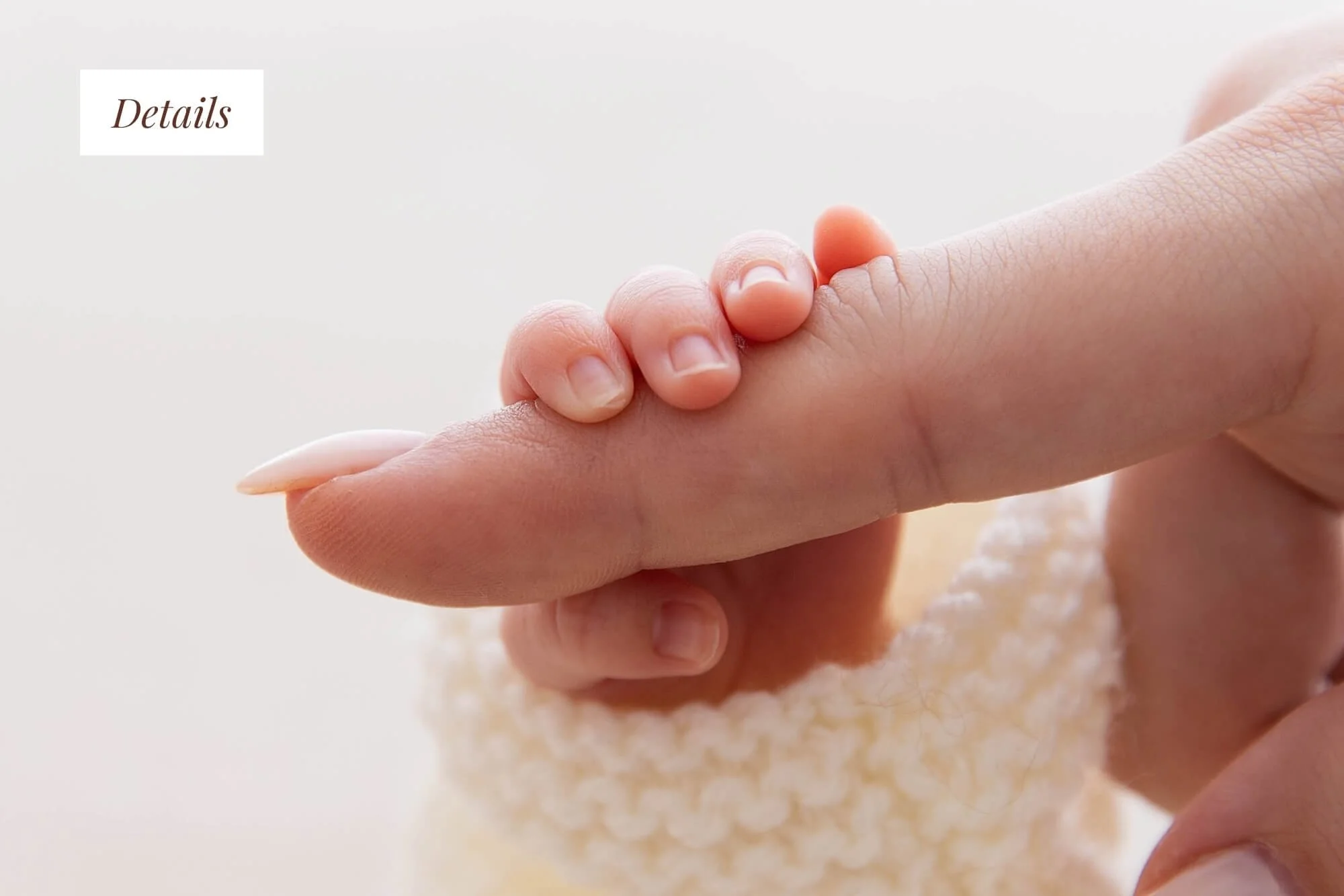 Mother cuddling baby's hand