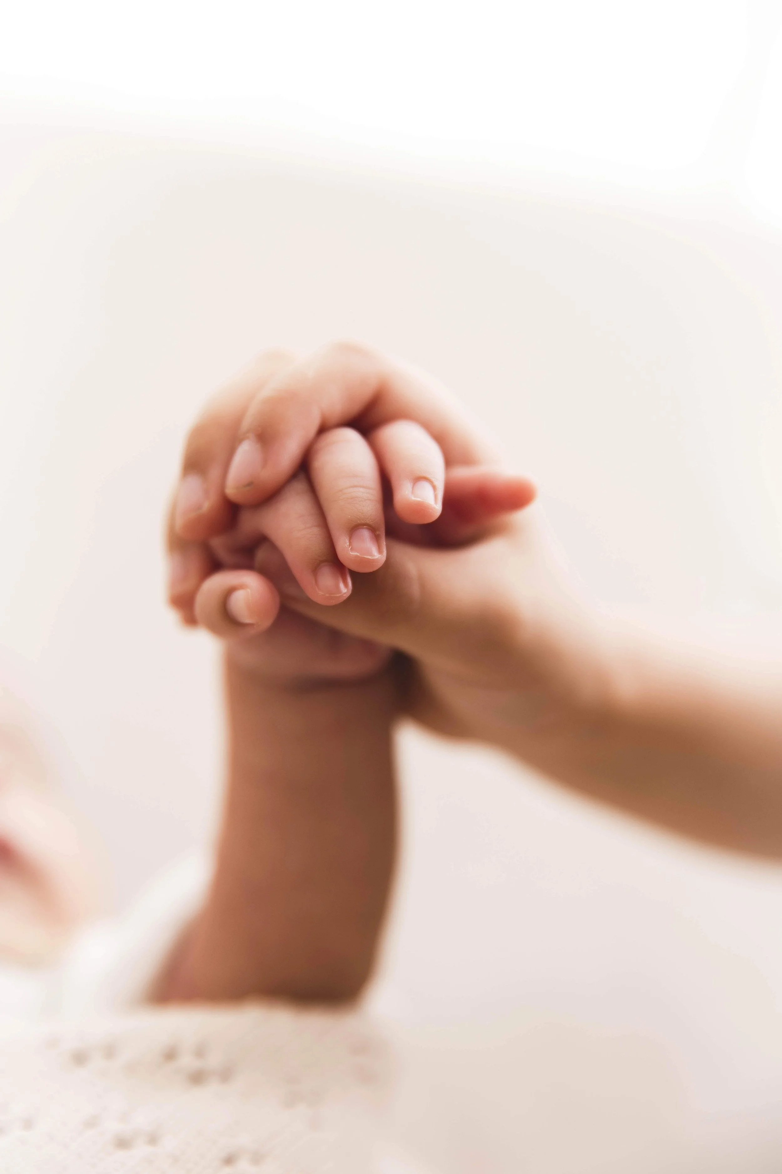 older sister holding baby hand
