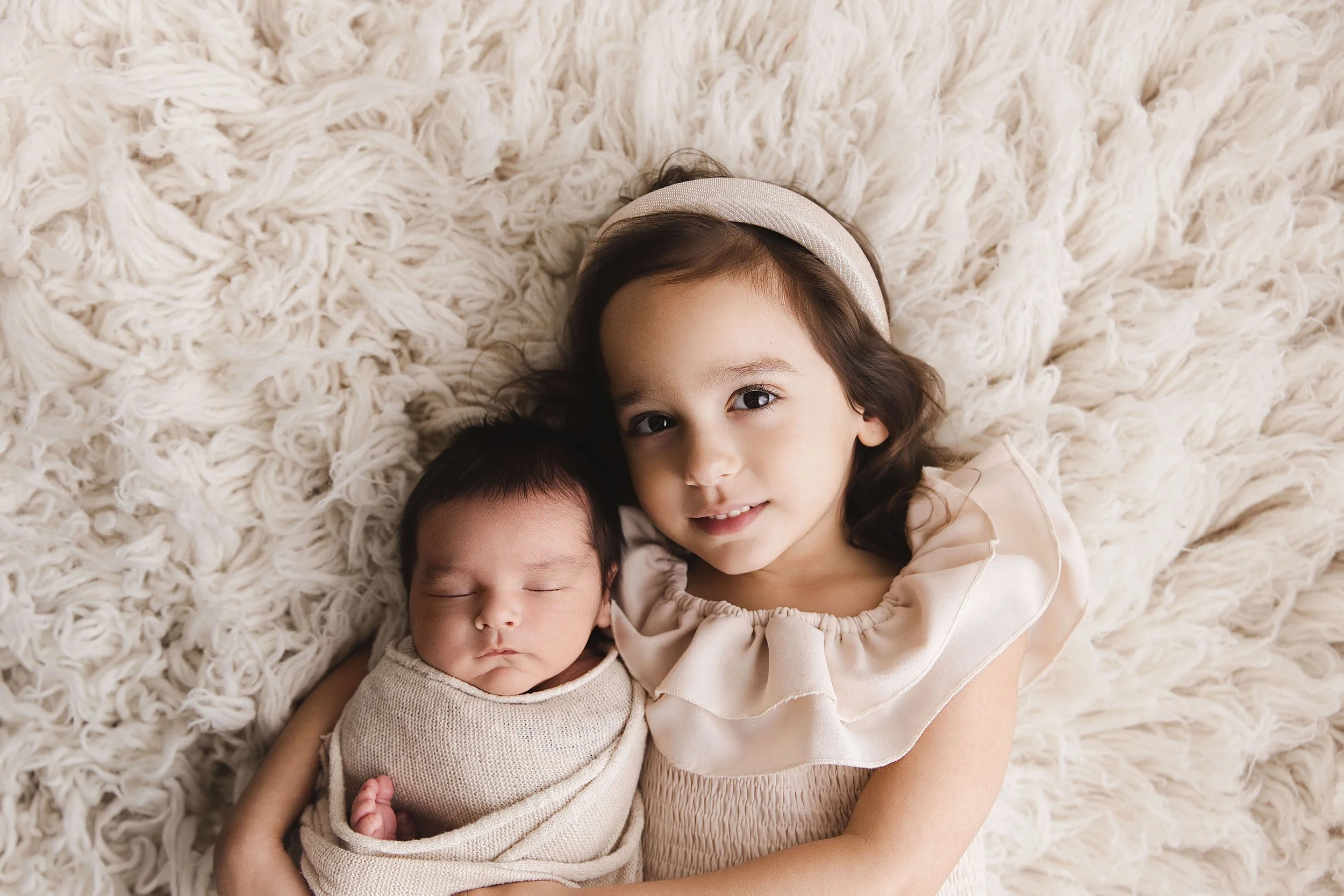 Sister with baby brother on rug