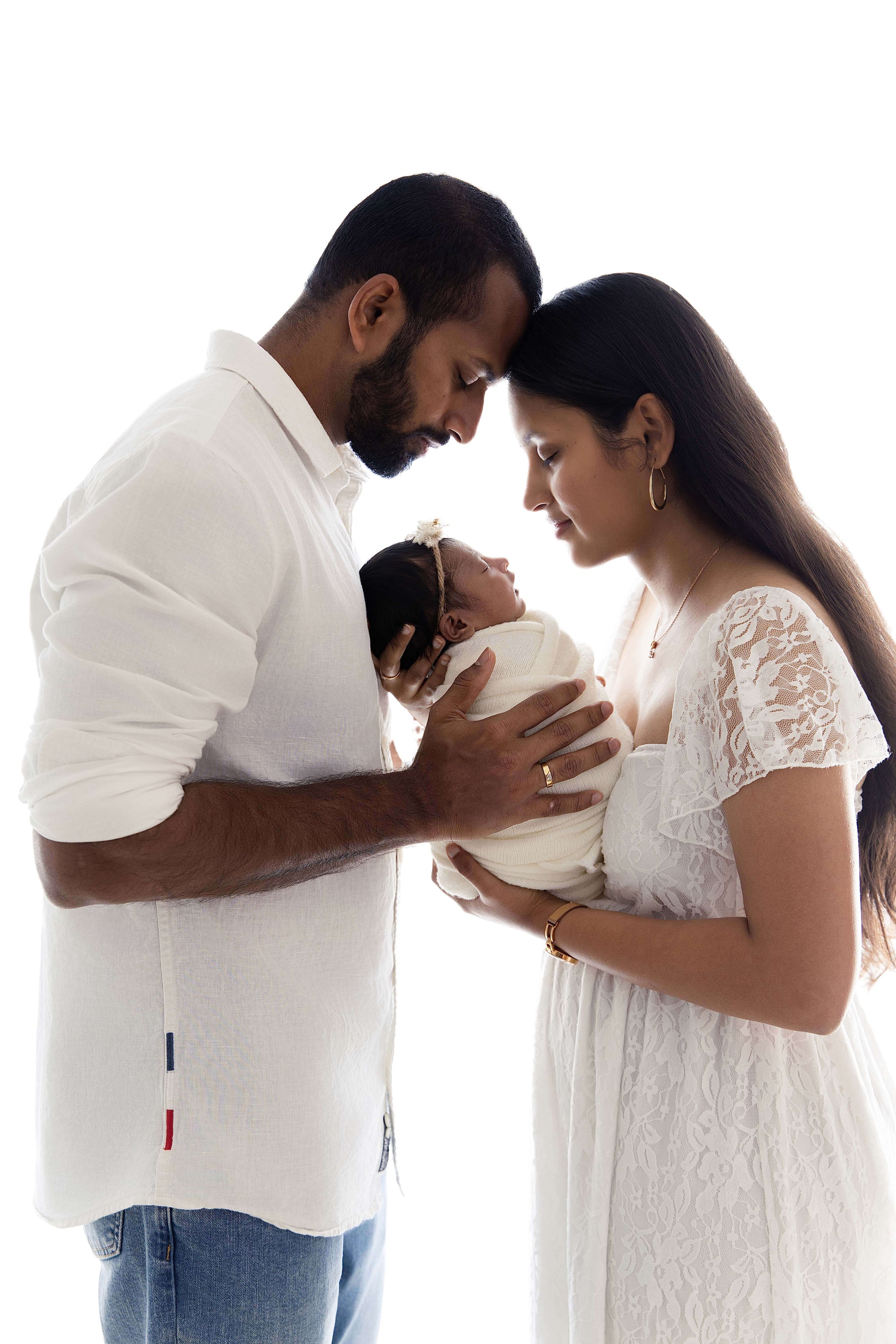 parents holding baby backlit image